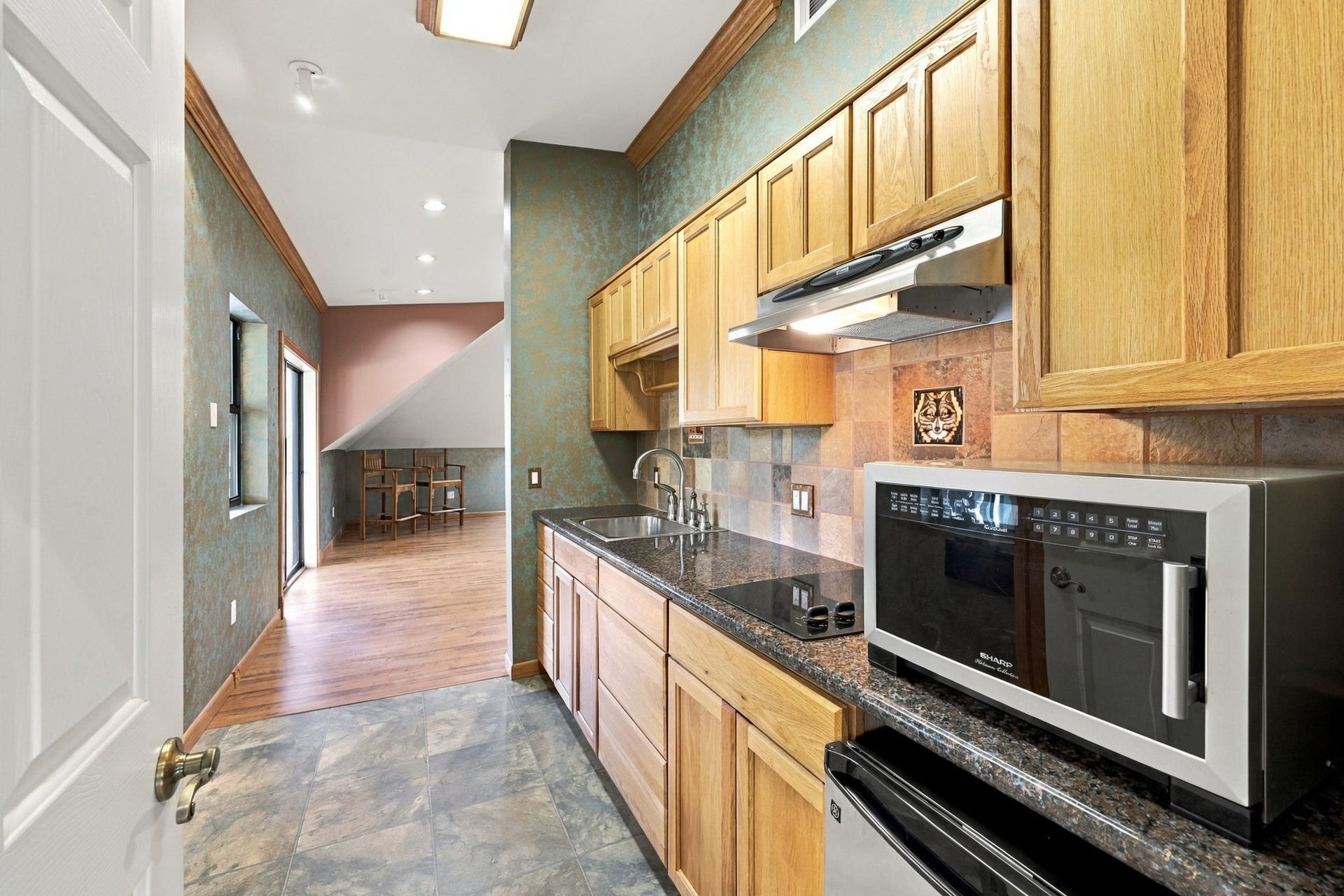 4711 Westerdale Drive, Fulshear, TX 77441 The apartment Kitchen is equipped with granite countertops, a stainless-steel sink, a two-burner electric cooktop, a microwave, and a convenient beverage refrigerator. A functional and well-appointed space for comfortable guest or extended-stay living.