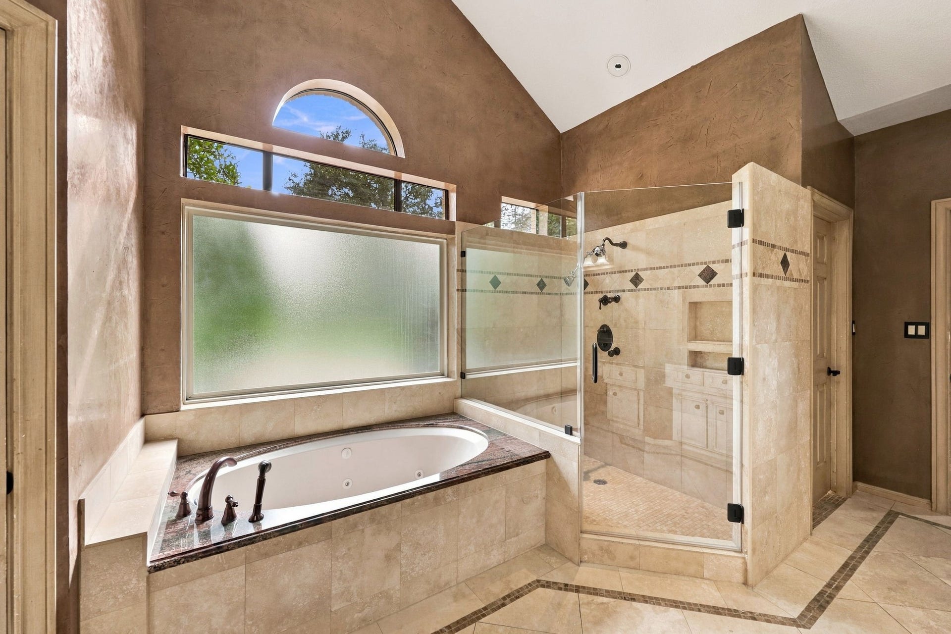 4711 Westerdale Drive, Fulshear, TX 77441 The spacious jetted soaking tub is beautifully positioned beneath a privacy glass window, allowing natural light while maintaining privacy. Featuring an elegant granite and tile surround with coordinating oil-rubbed bronze fixtures, this inviting space is perfect for relaxing and unwinding.