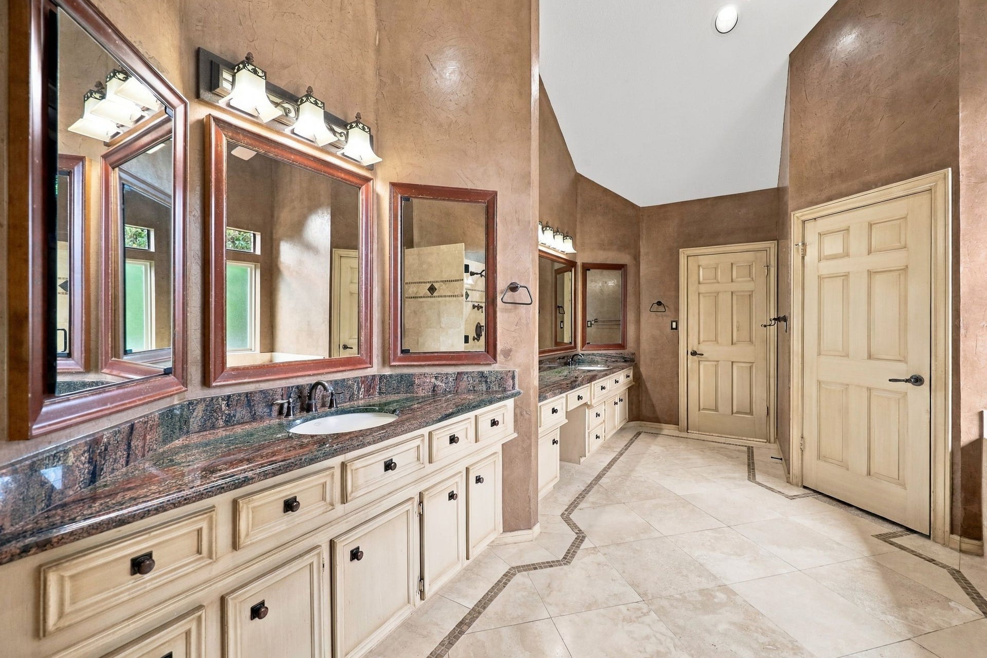 4711 Westerdale Drive, Fulshear, TX 77441 The spacious Primary Bath offers a touch of luxury with separate double vanity areas, gorgeous granite countertops, undermount sinks, and beautifully framed mirrors. Two large closets provide ample storage, while elegant tile finishes add to the appeal. This well-appointed space offers a wonderful blend of comfort, style, and functionality.