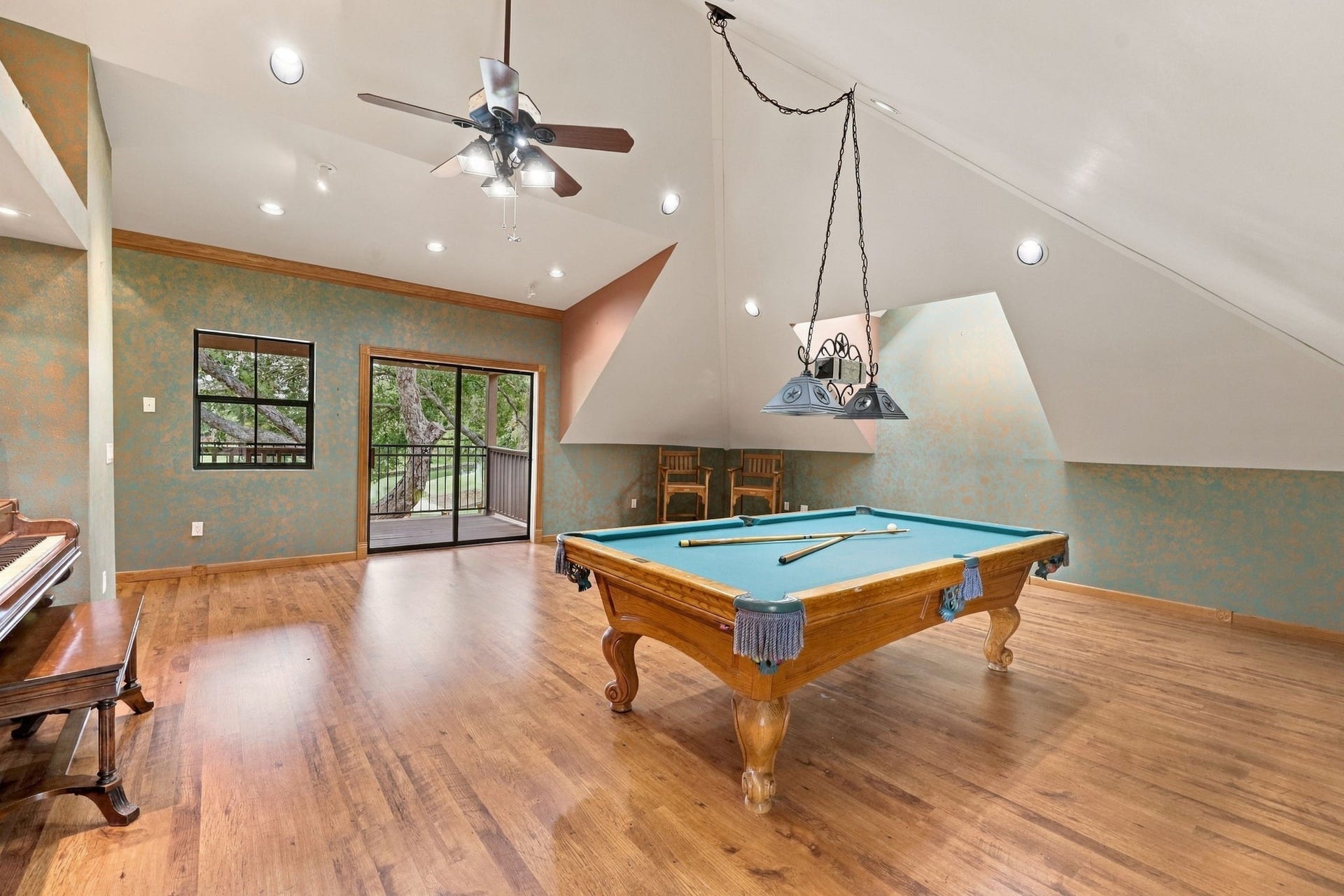 4711 Westerdale Drive, Fulshear, TX 77441 This versatile space can easily serve as an additional Bedroom, Game Room, or TV lounge, offering flexibility to suit your needs. Sliding glass doors open to the upstairs balcony, where you can enjoy beautiful waterfront views. The pool table will remain with the property, while the piano is excluded from the sale.
