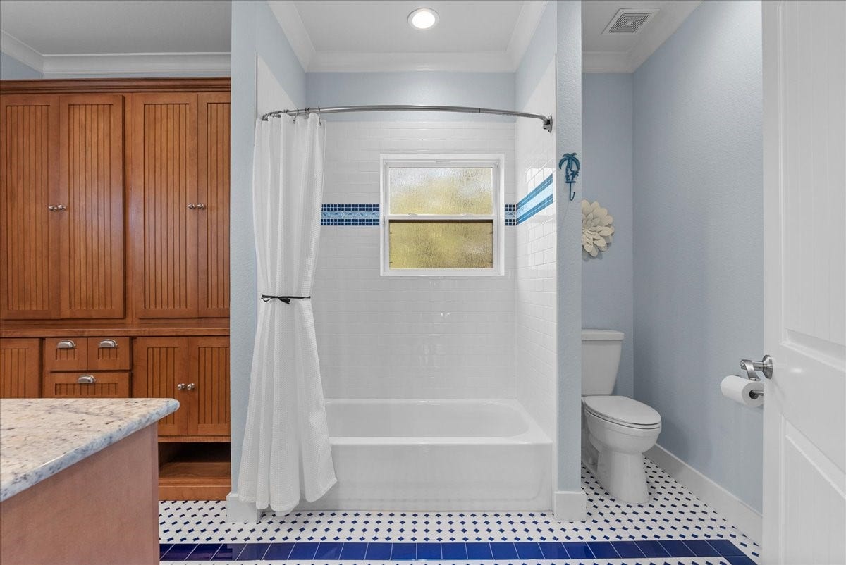 808 Elm Road, Clear Lake Shores, TX 77565 Roomy second-floor bath shared by the two secondary bedrooms, featuring abundant cabinetry, dual vanities and a tub/shower combination plus large storage closet.