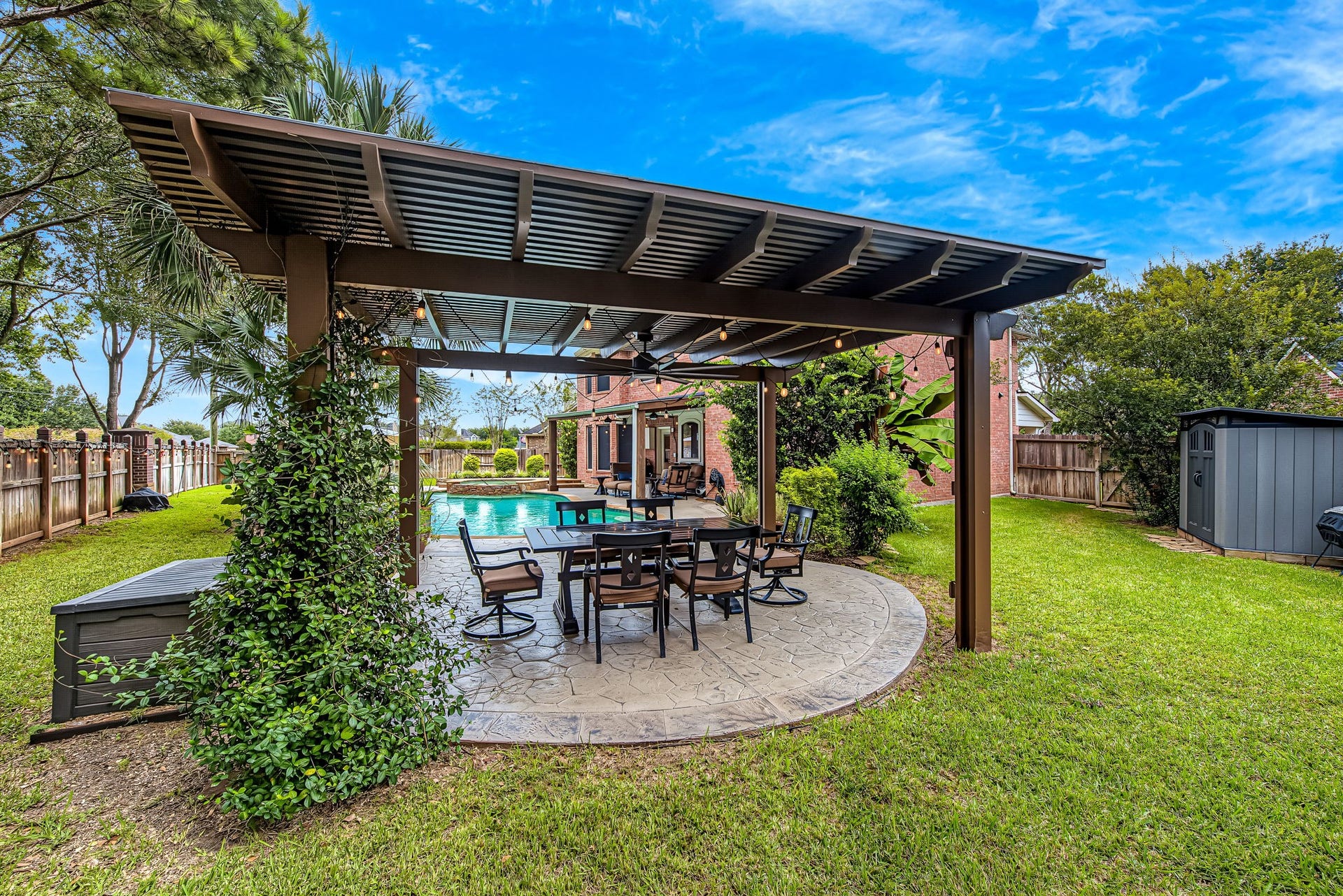 21223 Dover Park Lane, Katy, TX 77450 Experience outdoor relaxation in this charming backyard featuring a spacious pergola, elegant patio seating, and a sparkling pool, surrounded by lush greenery for added privacy.