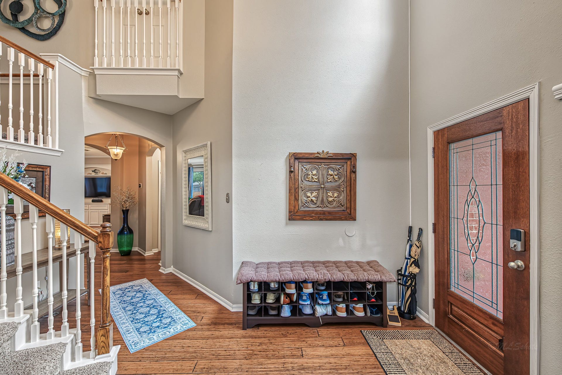 21223 Dover Park Lane, Katy, TX 77450 Inviting entryway with a warm wooden door featuring decorative glass, a cozy shoe bench, and elegant stairway leading to the upper level, all complemented by stylish accents and ample natural light.