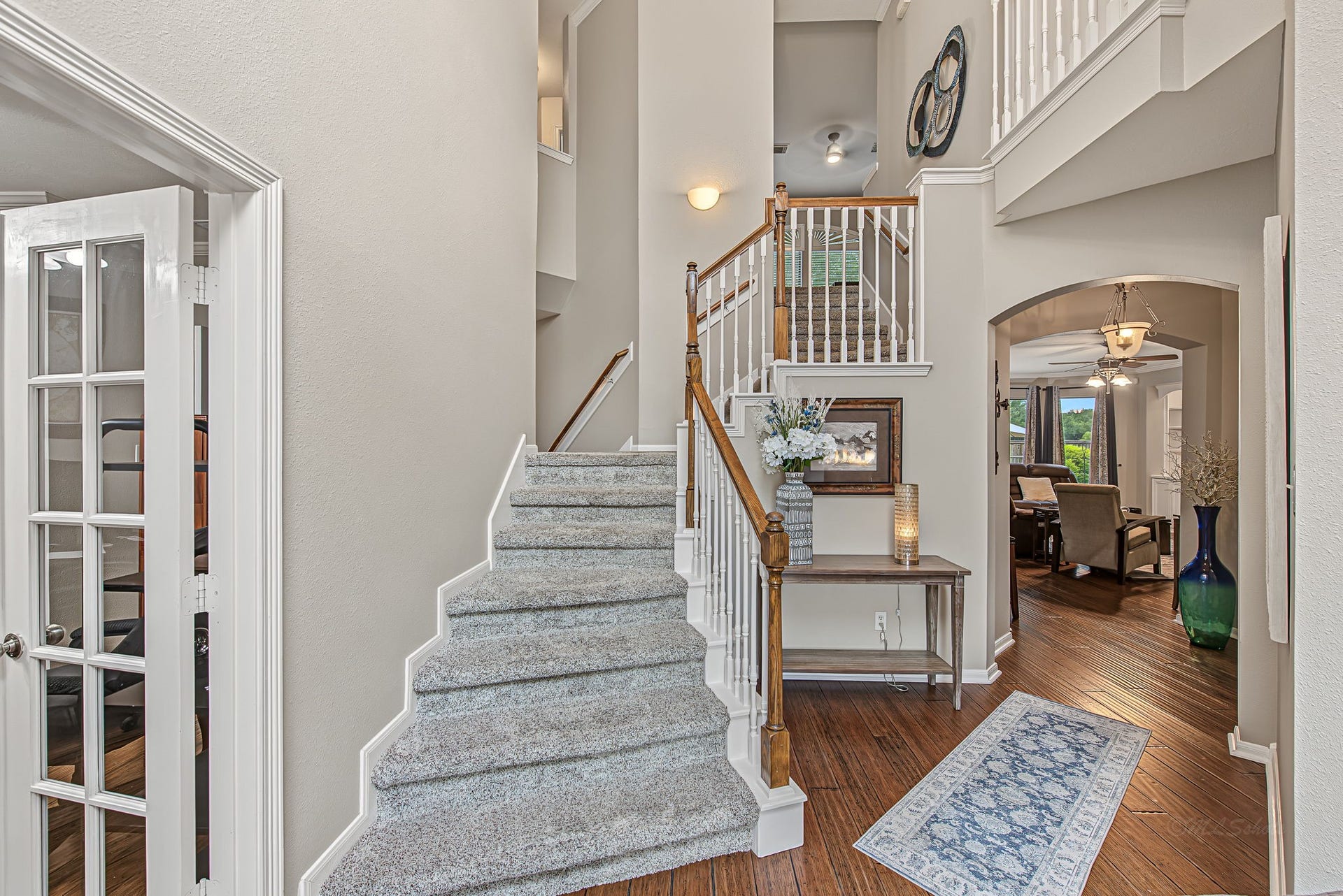 21223 Dover Park Lane, Katy, TX 77450 Elegant foyer with a grand staircase, featuring plush carpeting and wood accents. The open layout flows into a cozy living area, enhanced by natural light and stylish decor.