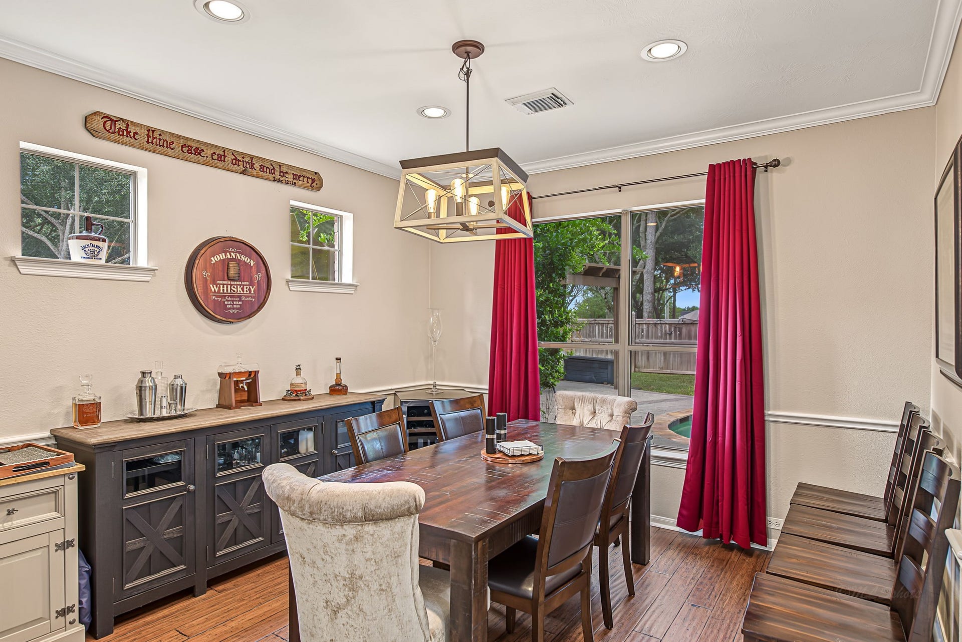 21223 Dover Park Lane, Katy, TX 77450 Elegant dining room with a warm, inviting atmosphere, featuring a wooden table, stylish lighting, and large windows with views of the lush backyard.