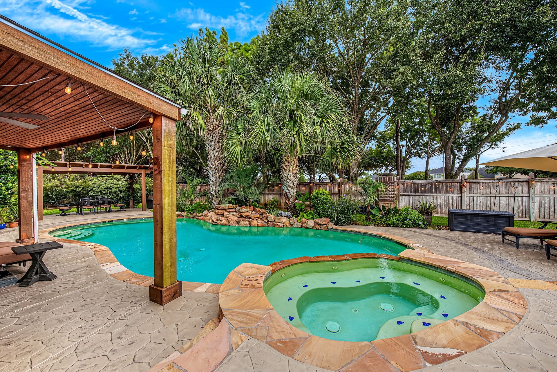21223 Dover Park Lane, Katy, TX 77450 Experience resort-style living with this stunning backyard oasis, featuring a sparkling pool and spa surrounded by lush landscaping and a charming pergola for shaded relaxation.