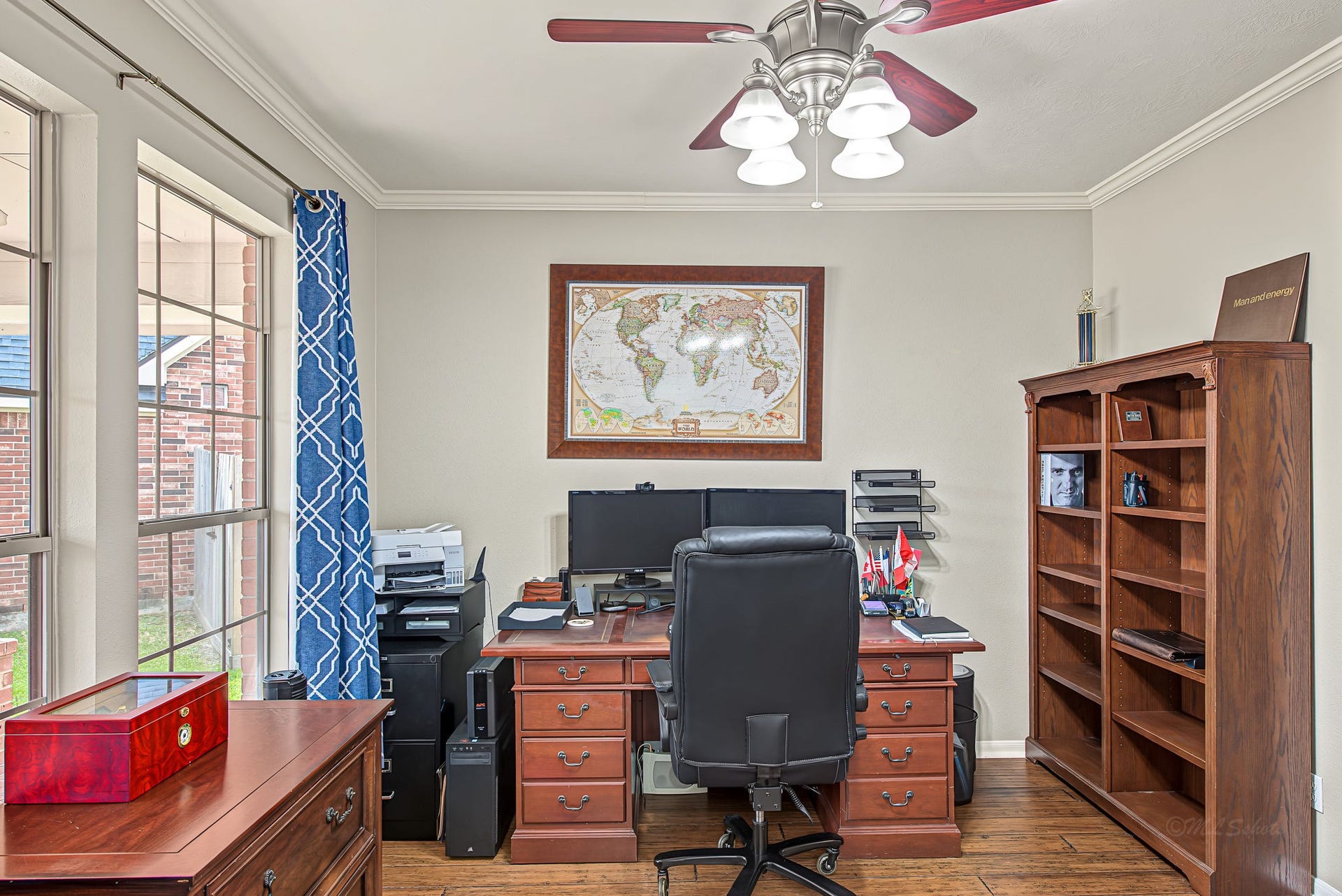 21223 Dover Park Lane, Katy, TX 77450 Bright and inviting home office featuring large windows, elegant wood furniture, and built-in shelving, perfect for productivity and organization.