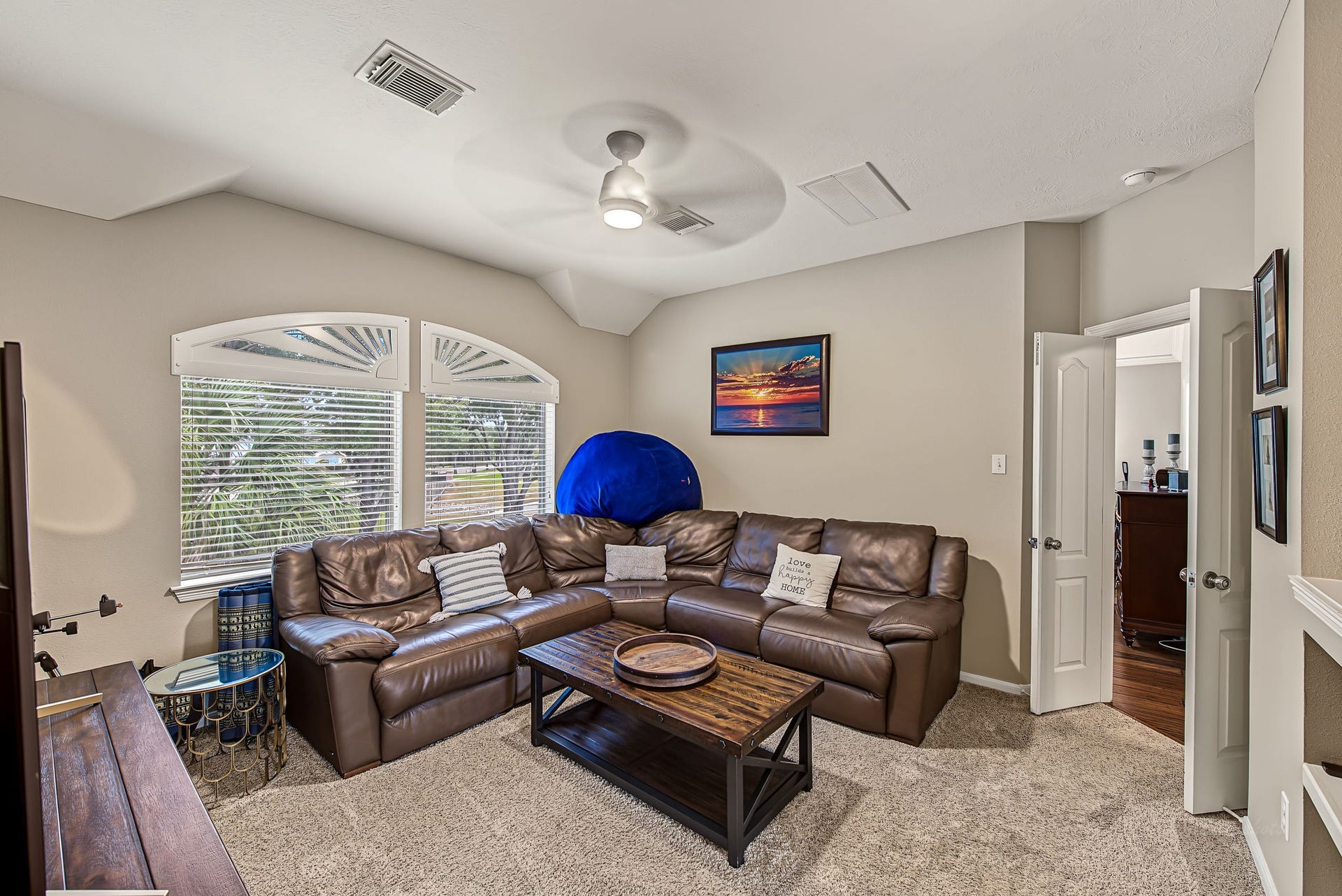 21223 Dover Park Lane, Katy, TX 77450 Cozy living area featuring a plush sectional sofa, large windows with abundant natural light, and a modern ceiling fan.