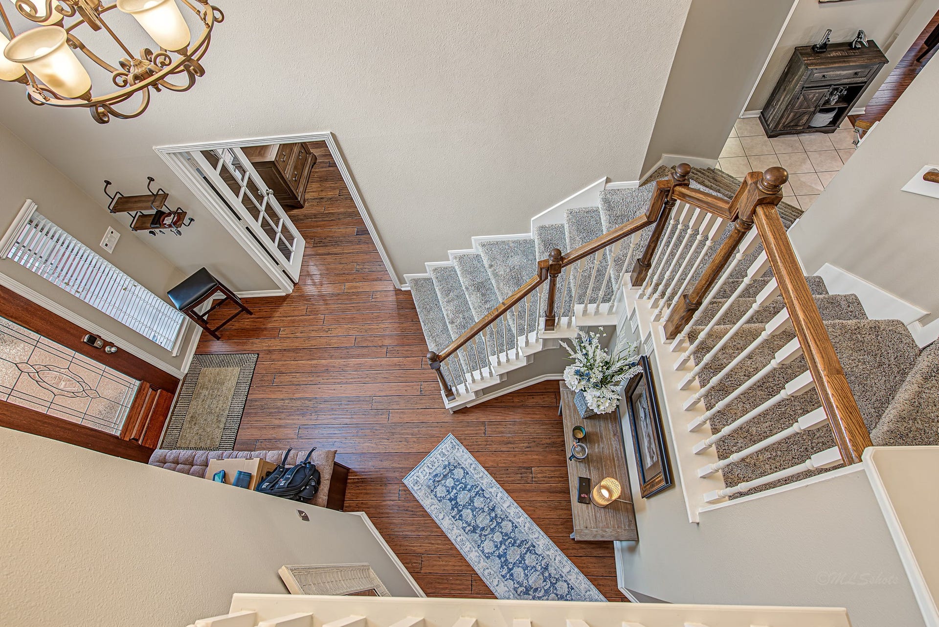 21223 Dover Park Lane, Katy, TX 77450 Elegant foyer with rich hardwood floors, a grand staircase, and a welcoming chandelier, offering a warm and inviting entrance.