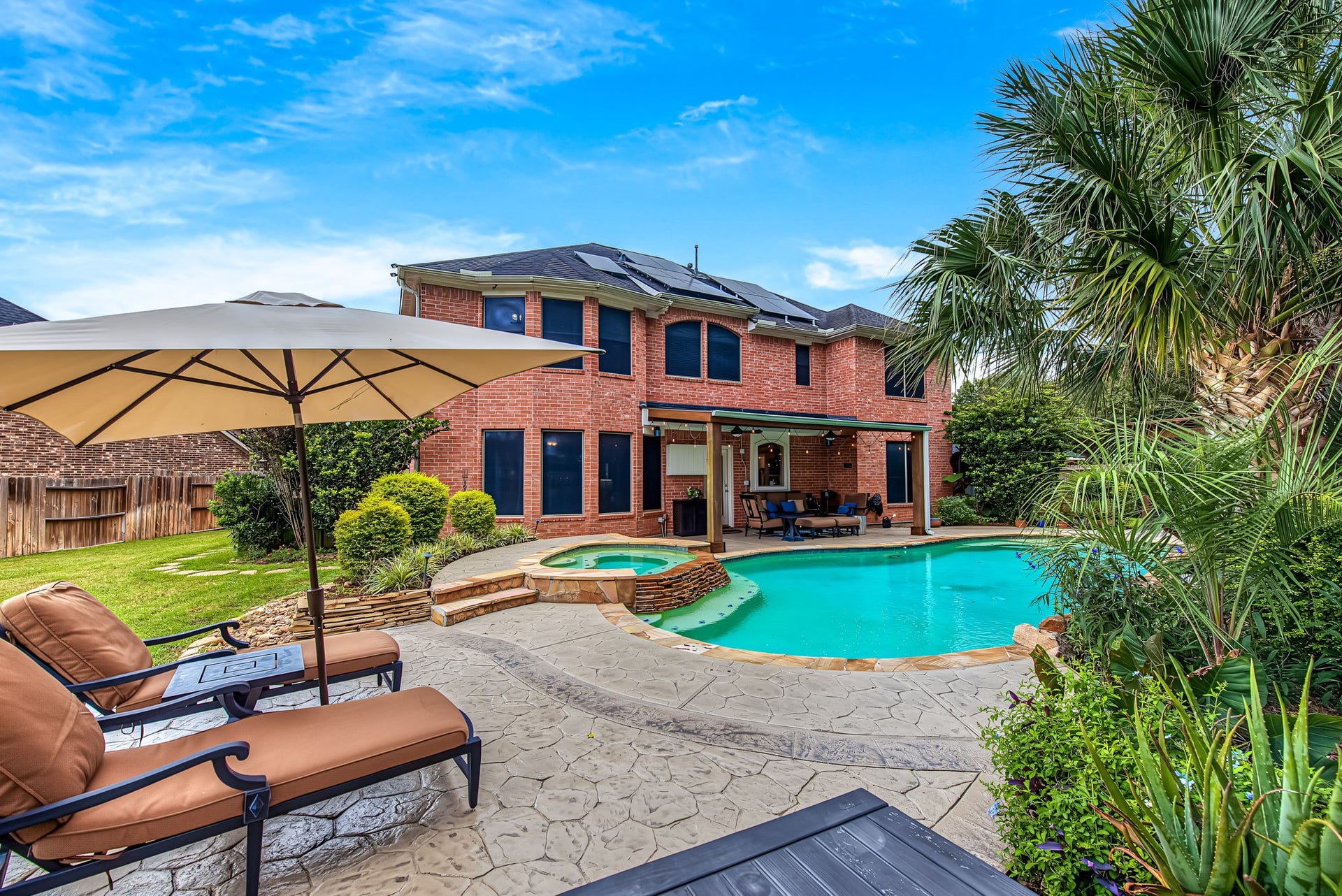 21223 Dover Park Lane, Katy, TX 77450 Stunning backyard oasis featuring a refreshing pool, spacious patio with seating, and lush landscaping, perfect for outdoor relaxation and entertaining.