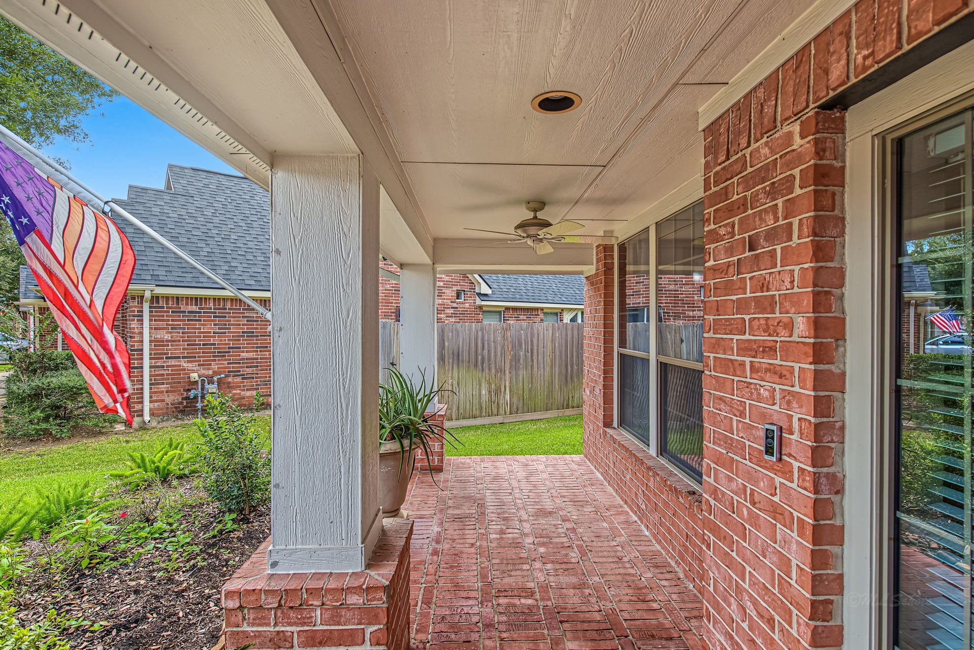 21223 Dover Park Lane, Katy, TX 77450 Charming covered brick patio with a ceiling fan, perfect for relaxing outdoors, overlooking a neatly landscaped yard.