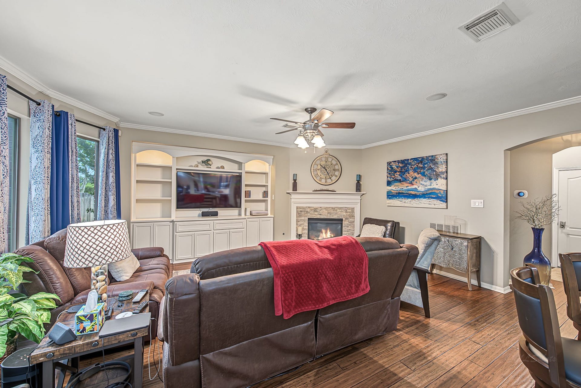 21223 Dover Park Lane, Katy, TX 77450 Cozy family room featuring a built-in entertainment center, elegant fireplace, and ample natural light from large windows.