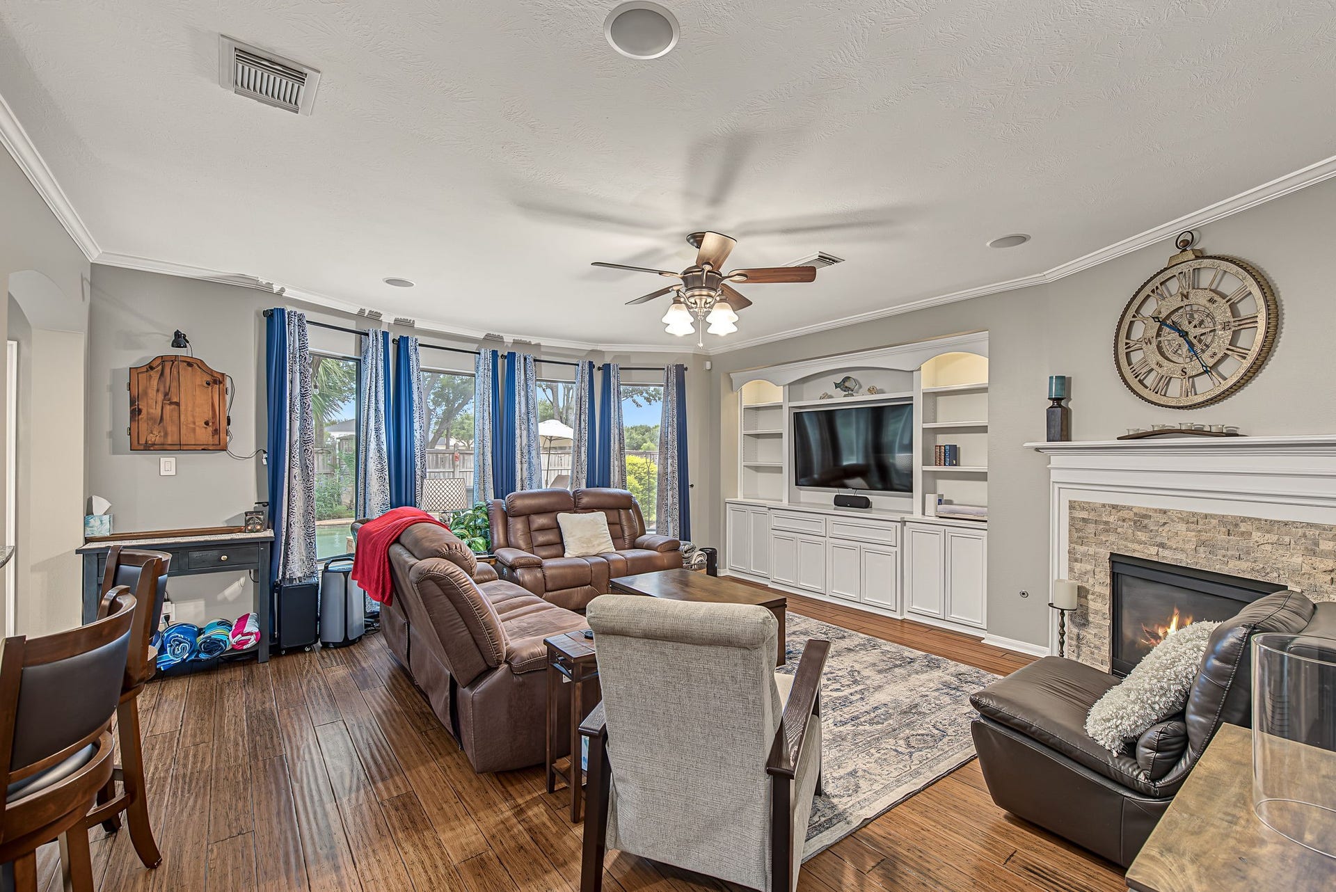 21223 Dover Park Lane, Katy, TX 77450 Spacious family room with elegant hardwood floors, a cozy fireplace, and a built-in entertainment center. Large windows provide natural light and a view of the backyard.