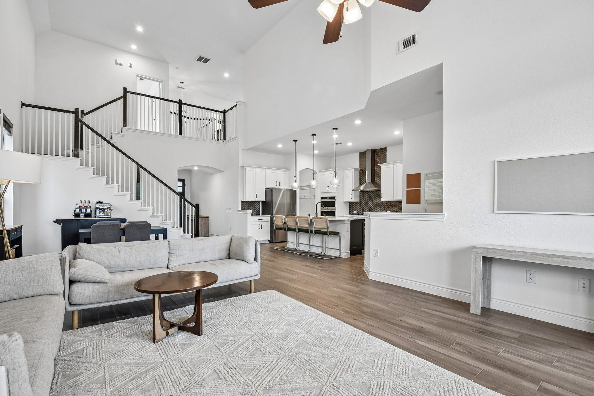 24110 Hawthorn Breeze Way, Katy, TX 77493 Two-story family room anchored by a floor-to-ceiling tile fireplace and dramatic wall of windows