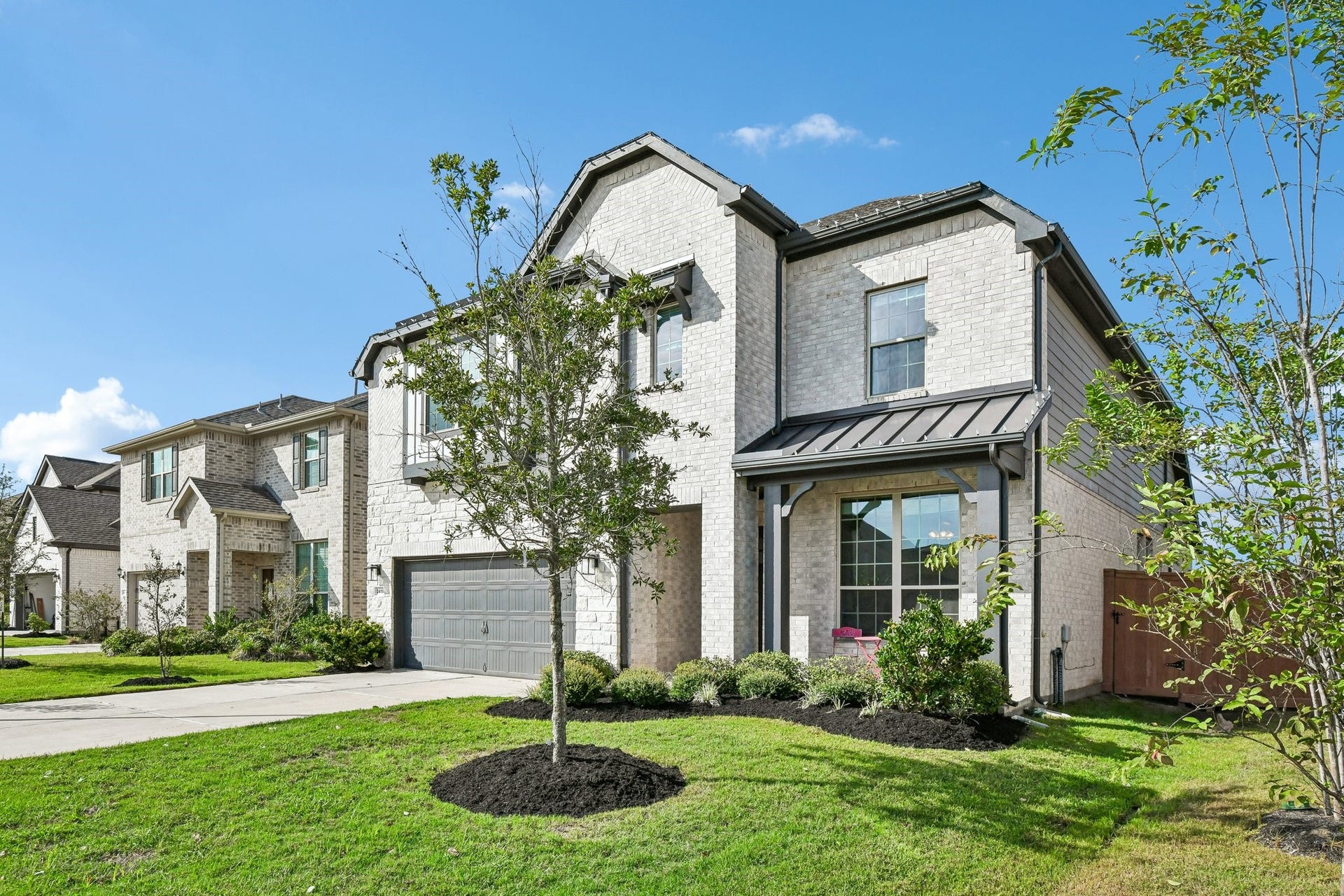 24110 Hawthorn Breeze Way, Katy, TX 77493 Full front exterior with herringbone brick detail, mixed masonry, and standing-seam metal roof accent