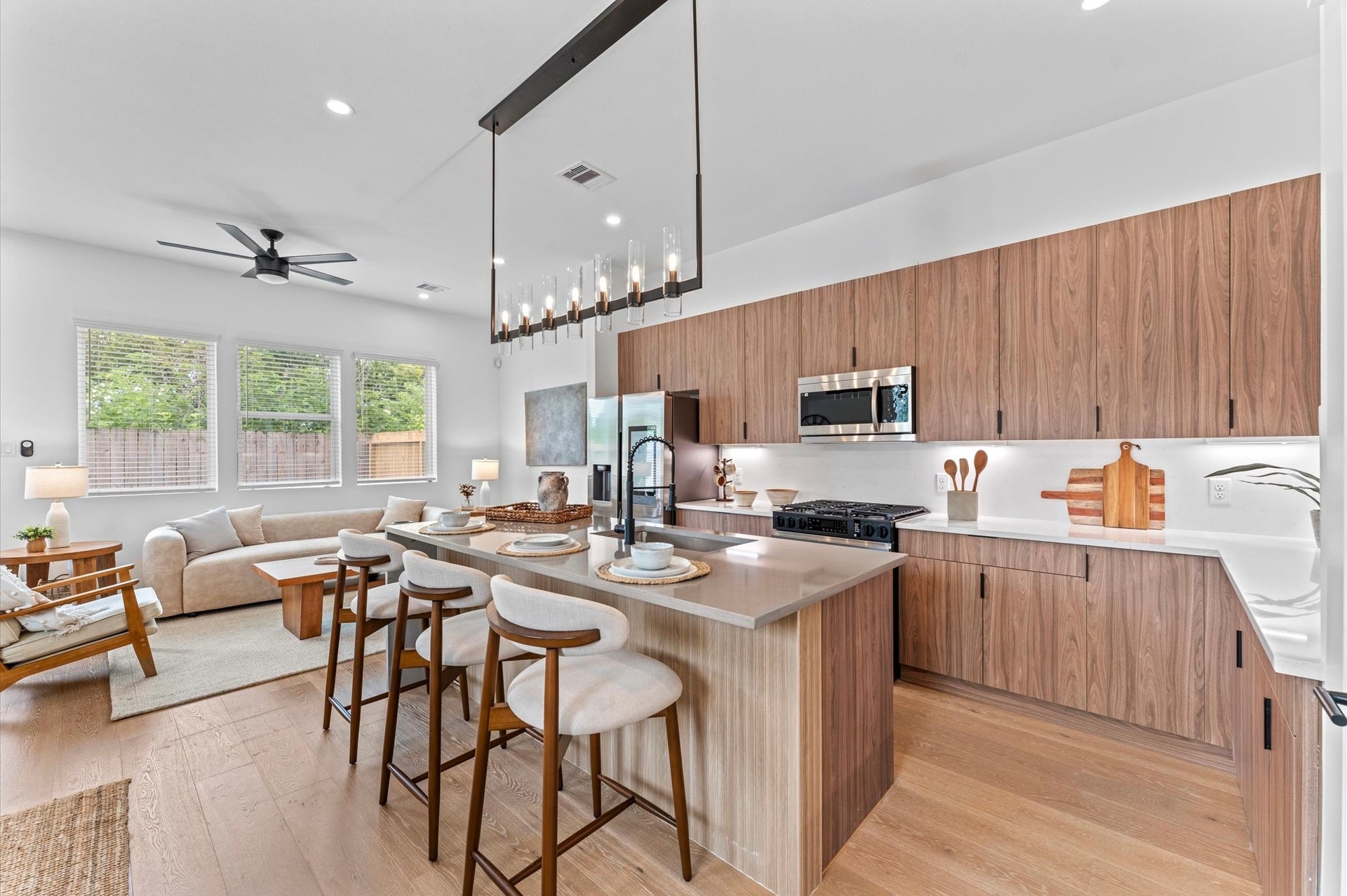 1009 Tuskegee Heights Lane, Houston, TX 77091 This stunning kitchen island is the centerpiece of a modern open-concept layout, featuring a waterfall quartz countertop that cascades elegantly down one side for high-end look. Positioned to offer clear sightlines to the living and dining areas, as well as through French doors to the balcony, the island enhances both functionality and flow. Contemporary finishessuch as sleek cabinetry, bold pendant lighting, and integrated appliancesadd sophistication, while bar seating invites casual dining.