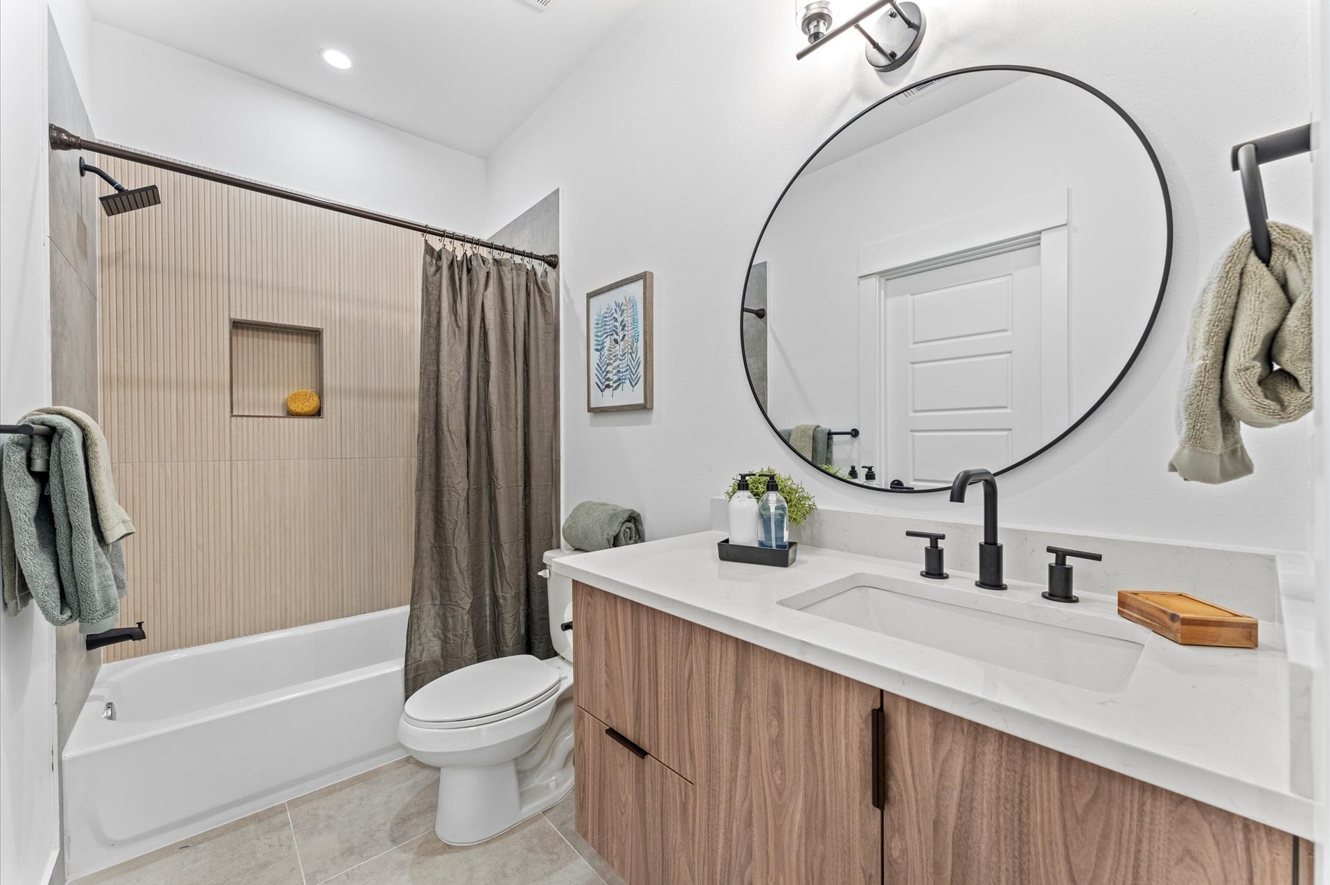 1009 Tuskegee Heights Lane, Houston, TX 77091 This thoughtfully designed Jack and Jill bathroom serves as a stylish and functional bridge between two spacious secondary bedrooms on the first floor. Featuring dual vanities, modern fixtures, and elegant tilework, the shared space offers privacy with separate entrances from each bedroom.