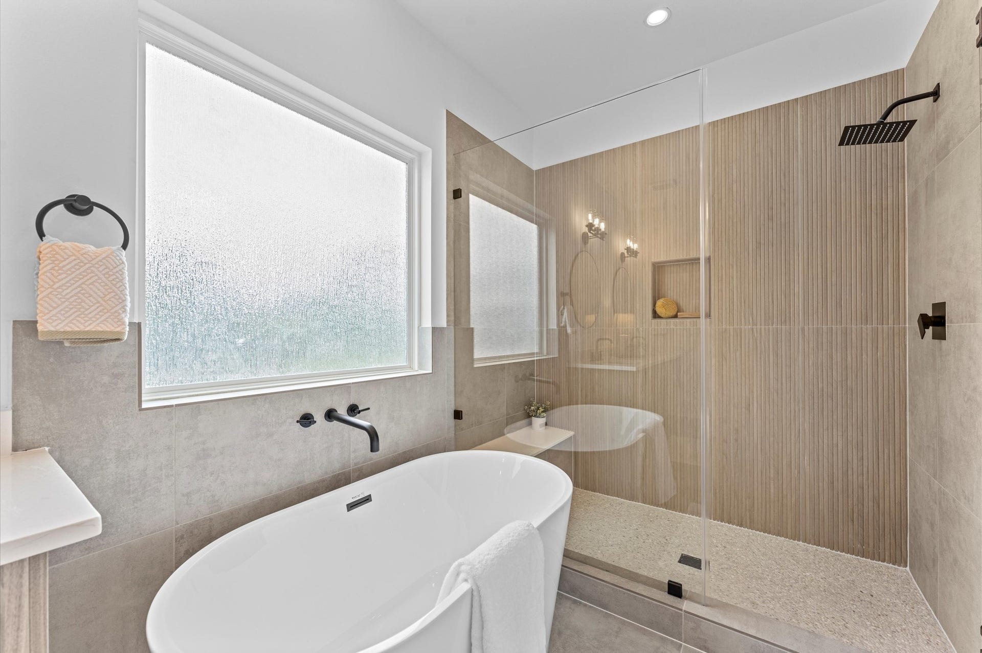 1009 Tuskegee Heights Lane, Houston, TX 77091 This luxurious primary bathroom blends modern elegance with spa-like comfort, featuring a spacious layout and contemporary selections throughout. A sleek double vanity with minimalist cabinetry and quartz countertops offers ample storage and style, while the glass-enclosed shower includes a built-in bench for added relaxation and convenience. The centerpiece is a sculptural freestanding soaking tub, perfectly positioned to invite unwinding after a long day.