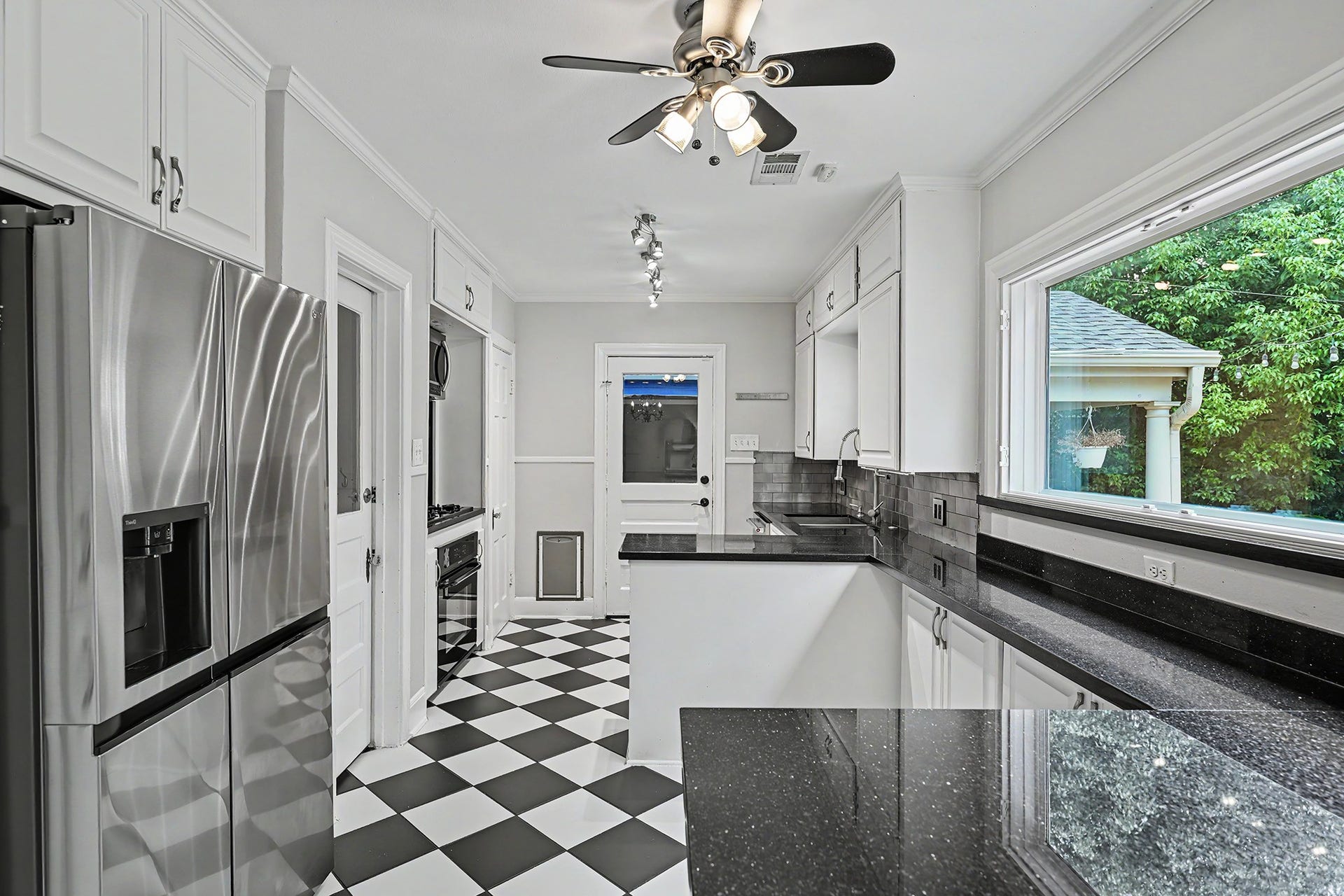 320 W 33rd Street, Houston, TX 77018 The kitchen features a large picture window overlooking the backyard, along with abundant cabinet storage and counter space.