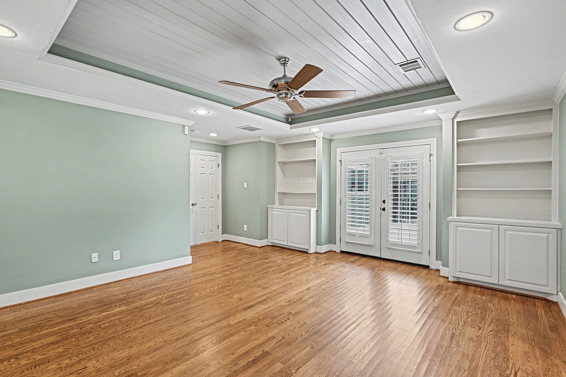 320 W 33rd Street, Houston, TX 77018 The spacious primary suite offers 3 walk-in closets, an ensuite bath, hardwood floors, built-in cabinetry and shelving, and French doors opening onto the back deck.