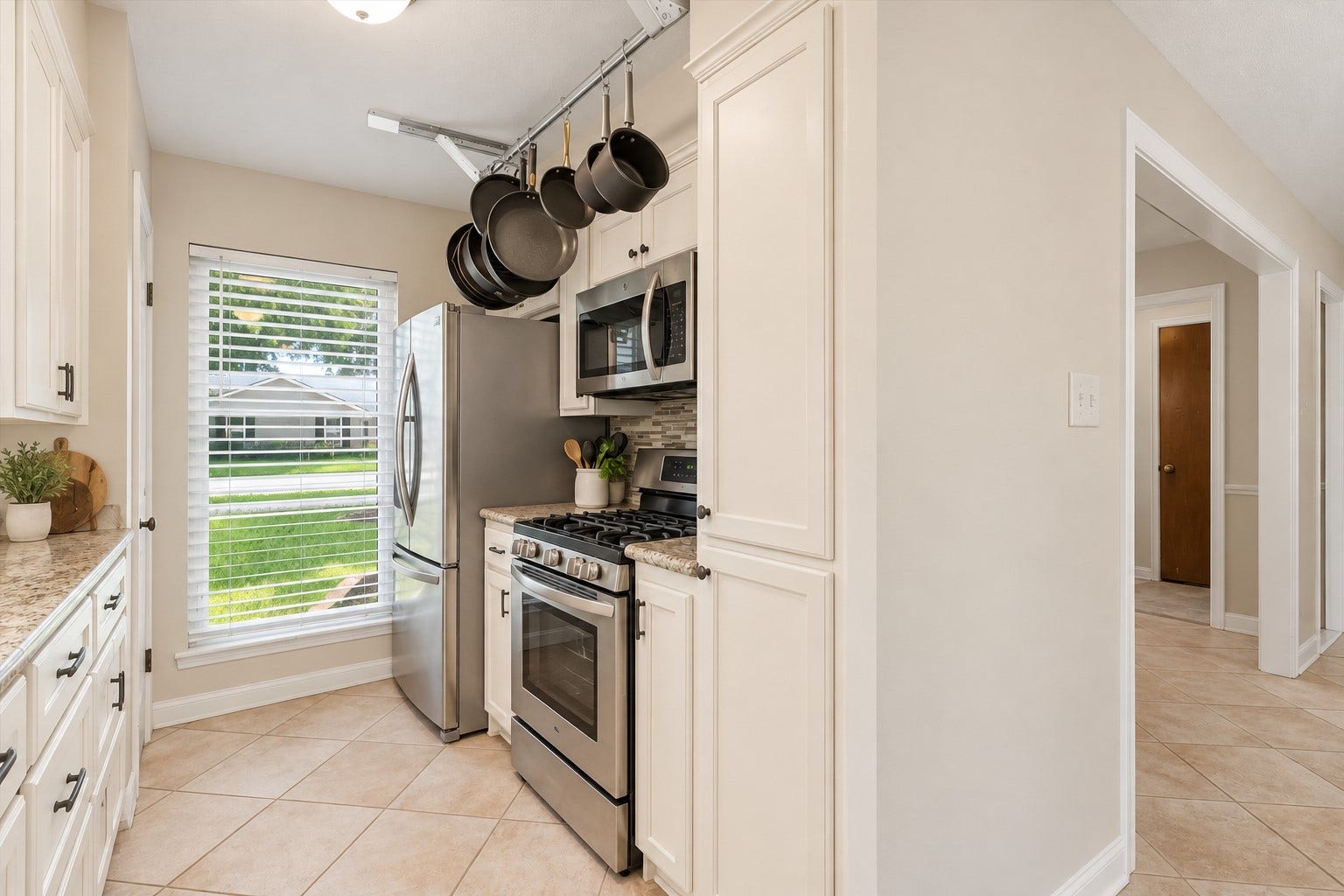2309 Halbert Drive, Pearland, TX 77581 Another view of the kitchen showcases the stainless steel stove, microwave and a large window with privacy blinds.