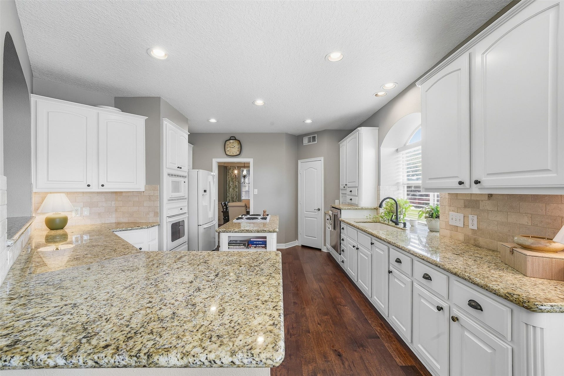 22514 Sierra Lake Court, Katy, TX 77494 This is a kitchen made for any chef with an Island stovetop and plenty of counterspace for cooking and entertaining! These Newly Painted Cabinets have a timeless feel with custom wood trim on the corners and Recipe
Book Rack on the end of the Island! The Can Lighting gives plenty of light and adds to the Openness throughout the space! Add the Gorgeous warm granite and Travertine Backsplash and you are all set to entertain your family and friends!