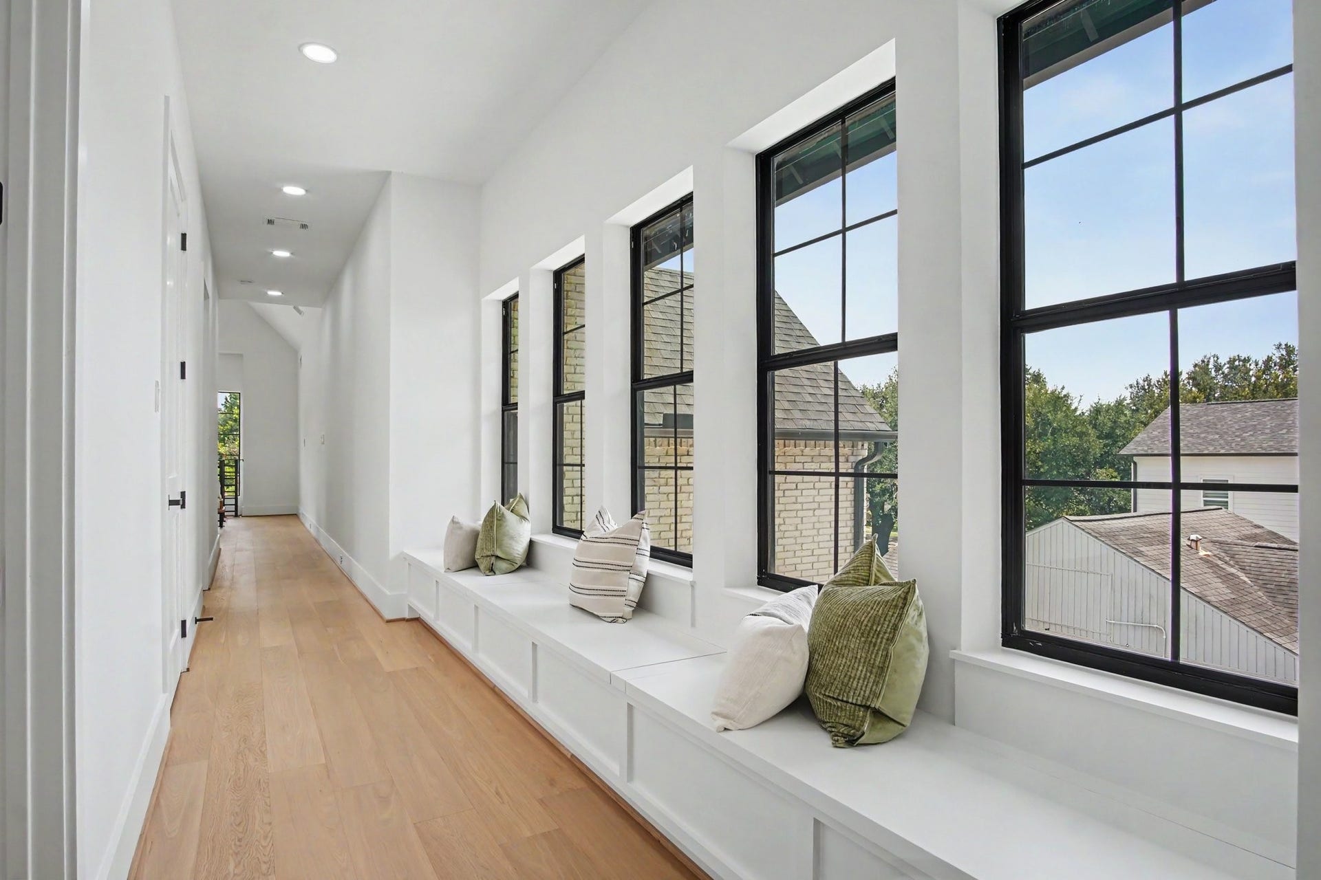 705 Walton Street, Houston, TX 77009 Bright and airy hallway with expansive windows, featuring a cozy window seat perfect for relaxation and taking in the view.