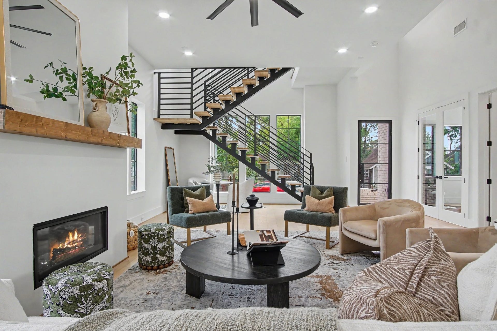 705 Walton Street, Houston, TX 77009 Stunning contemporary living room featuring a sleek open staircase and abundant natural light from large windows and glass doors.