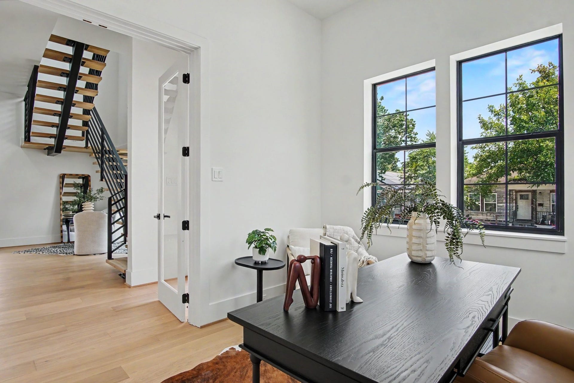 705 Walton Street, Houston, TX 77009 Bright and airy bedroom or home office with large windows, modern ceiling fan, and elegant furnishings, offering a serene workspace.