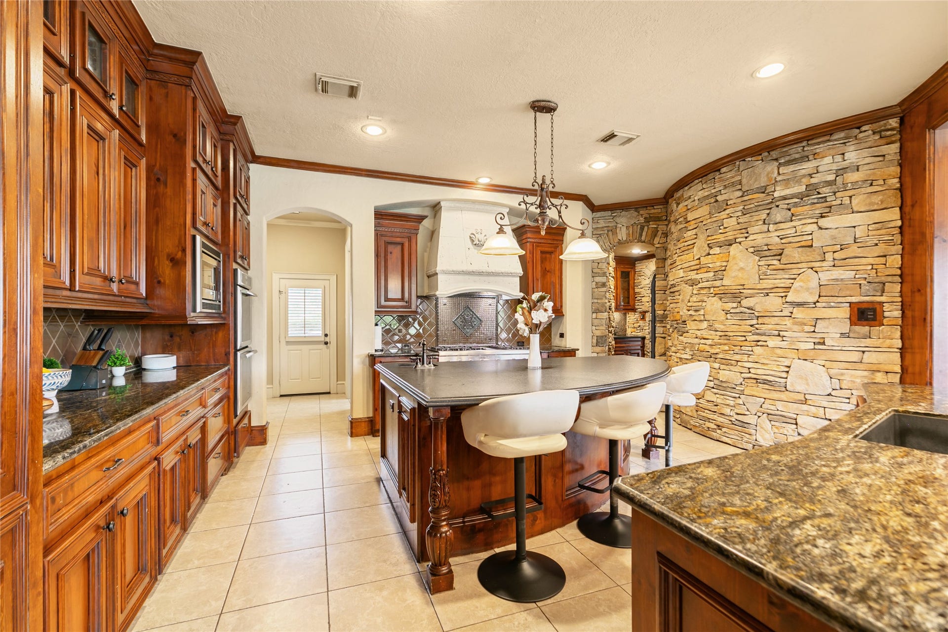 Beautiful stonework enhances the elegance of this stunning kitchen