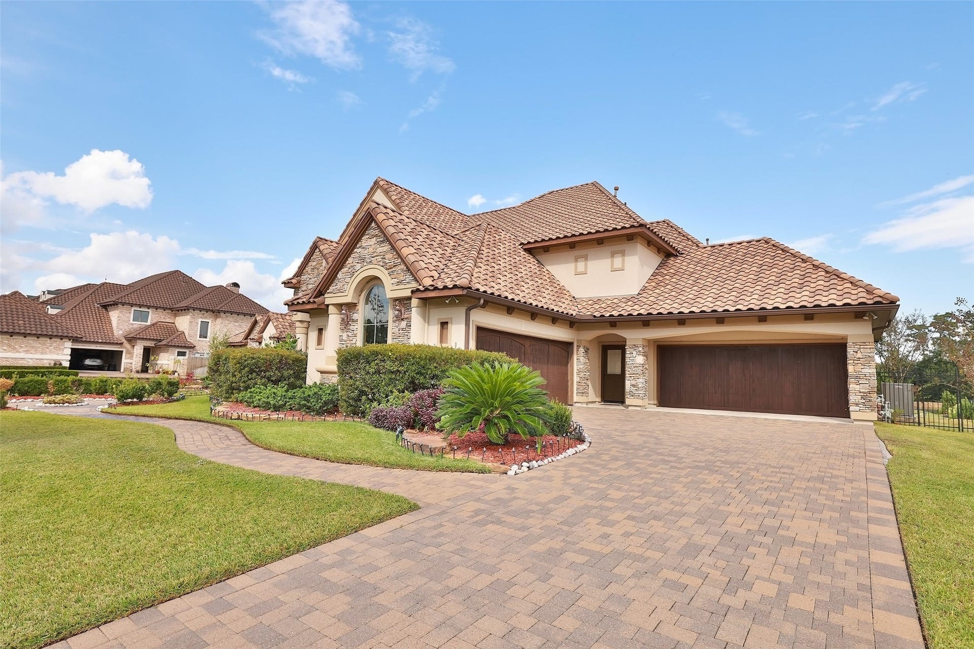 The double-wide driveway paired with a four-car garage provides generous space for vehicles and storage.