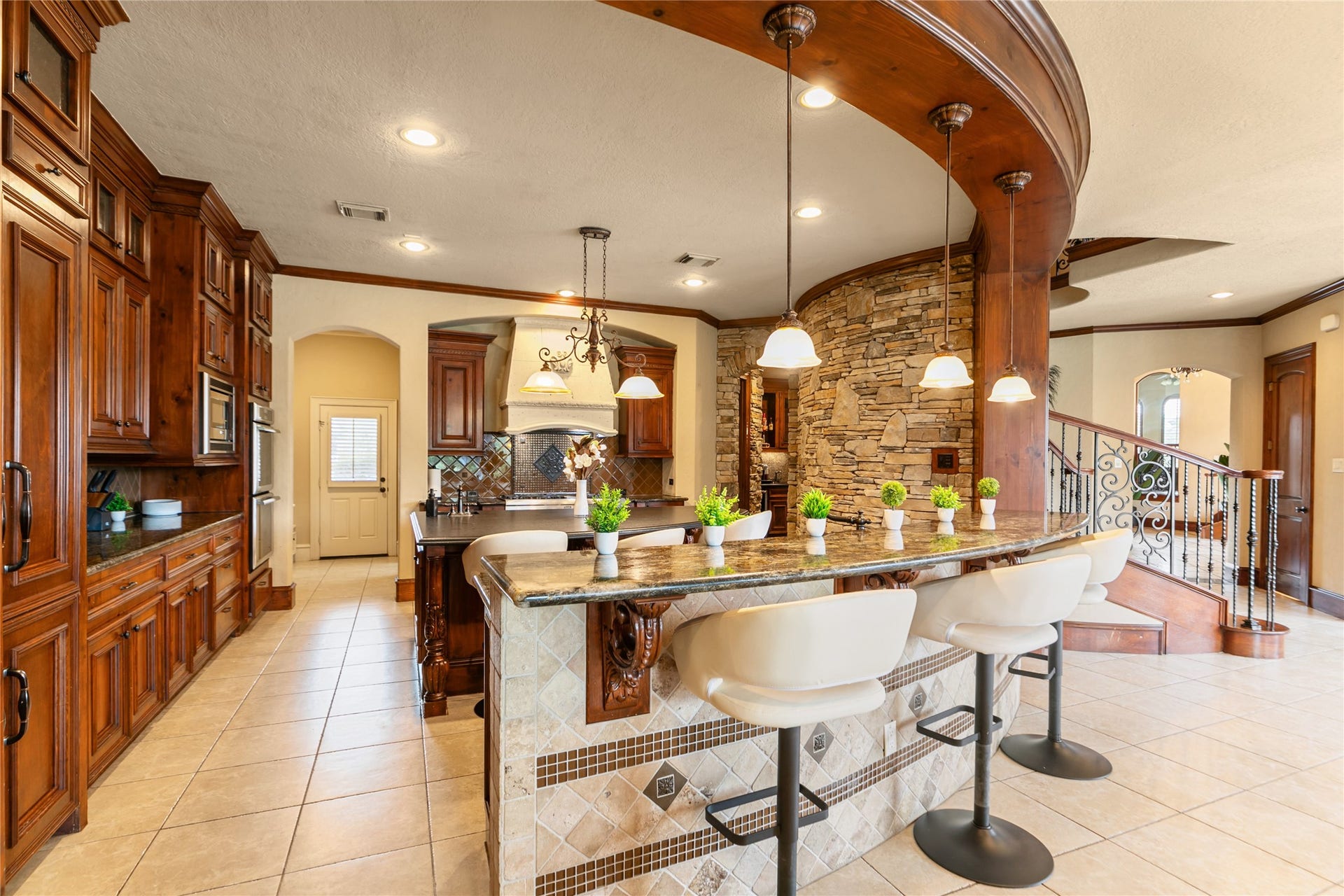 Lovely open kitchen with bar area.  Granite counters and attractive lighting add to the beauty of this space.