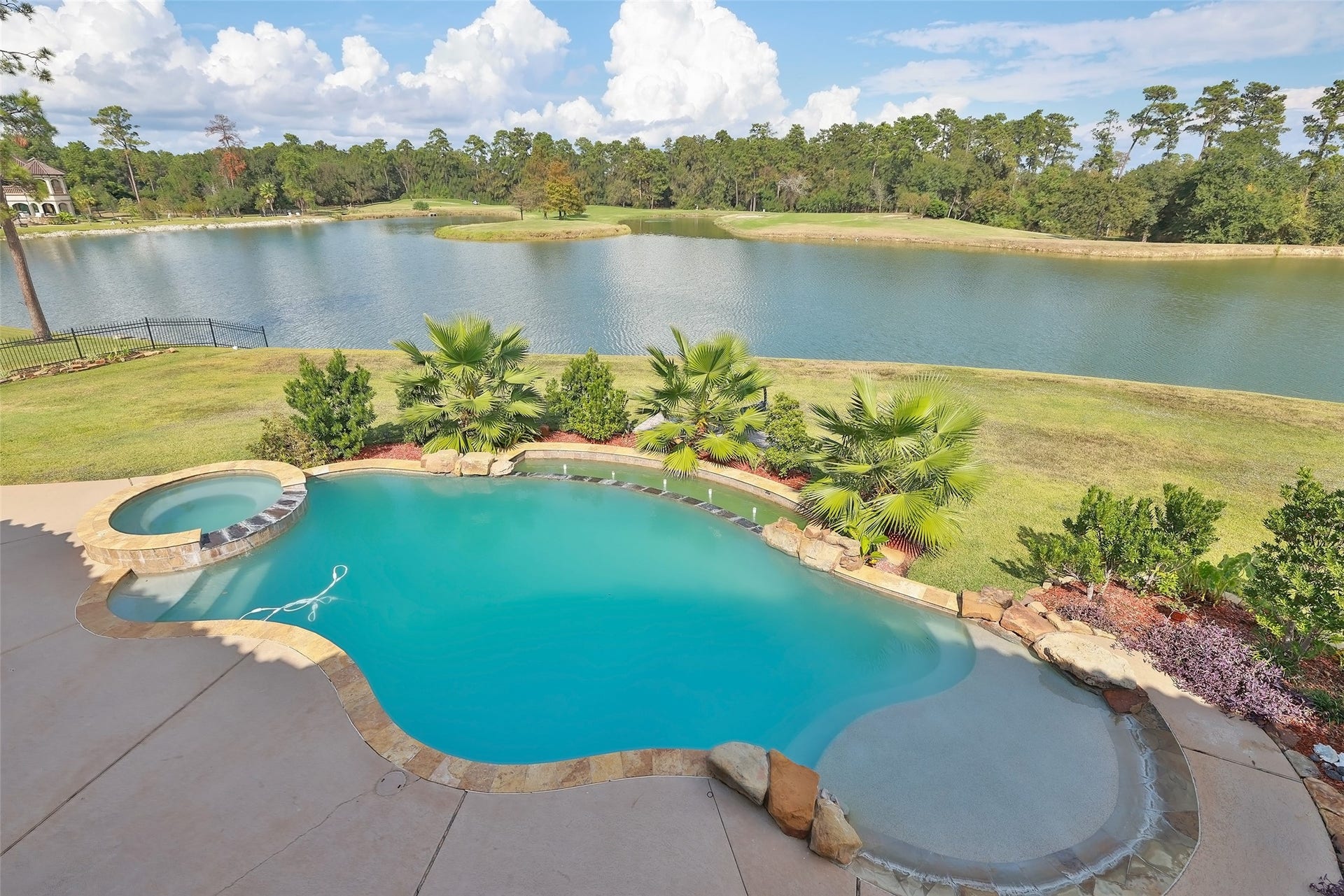 Gorgeous backyard view of beautifully landscaped pool area overlooking the lake and golf course.
