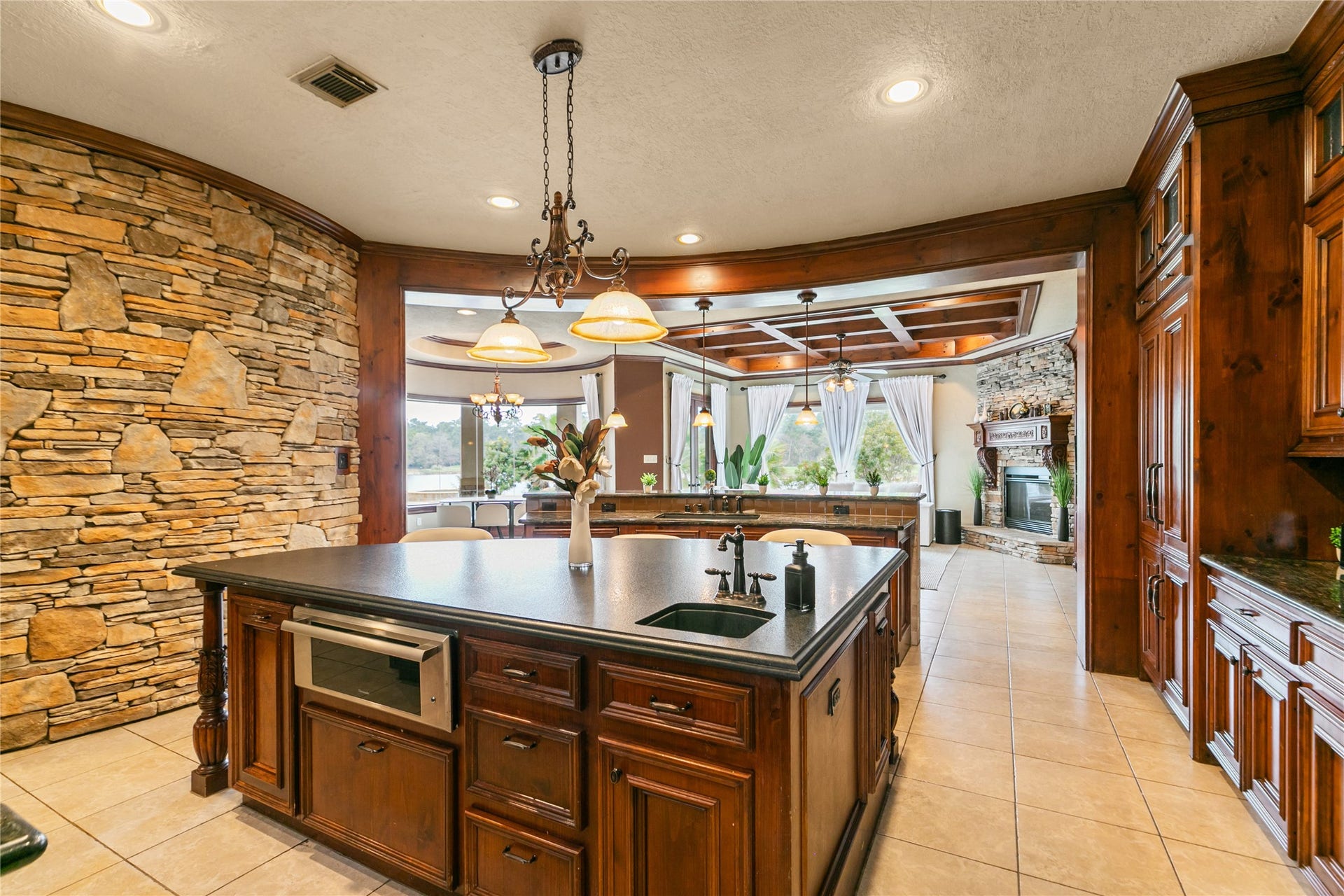 View from kitchen through den and into back yard through large windows of the den and breakfast area create a marvelous view when cooking or entertaining in the kitchen.  Beautiful rich, warm cabinets provide plenty of  storage.