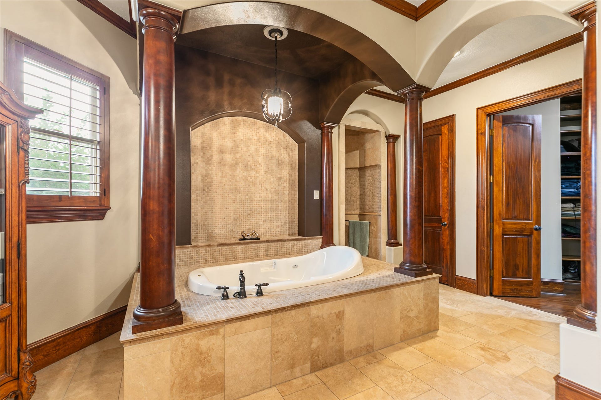 The expansive primary bathroom boasts an inviting tub, perfect for relaxation and rejuvenation.