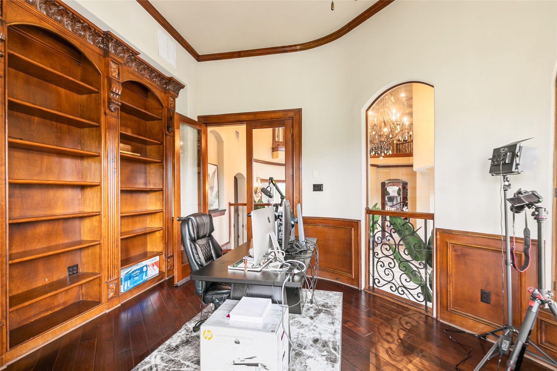 Rich wood flooring, wainscoting and built-in bookshelves create a beautiful work area.