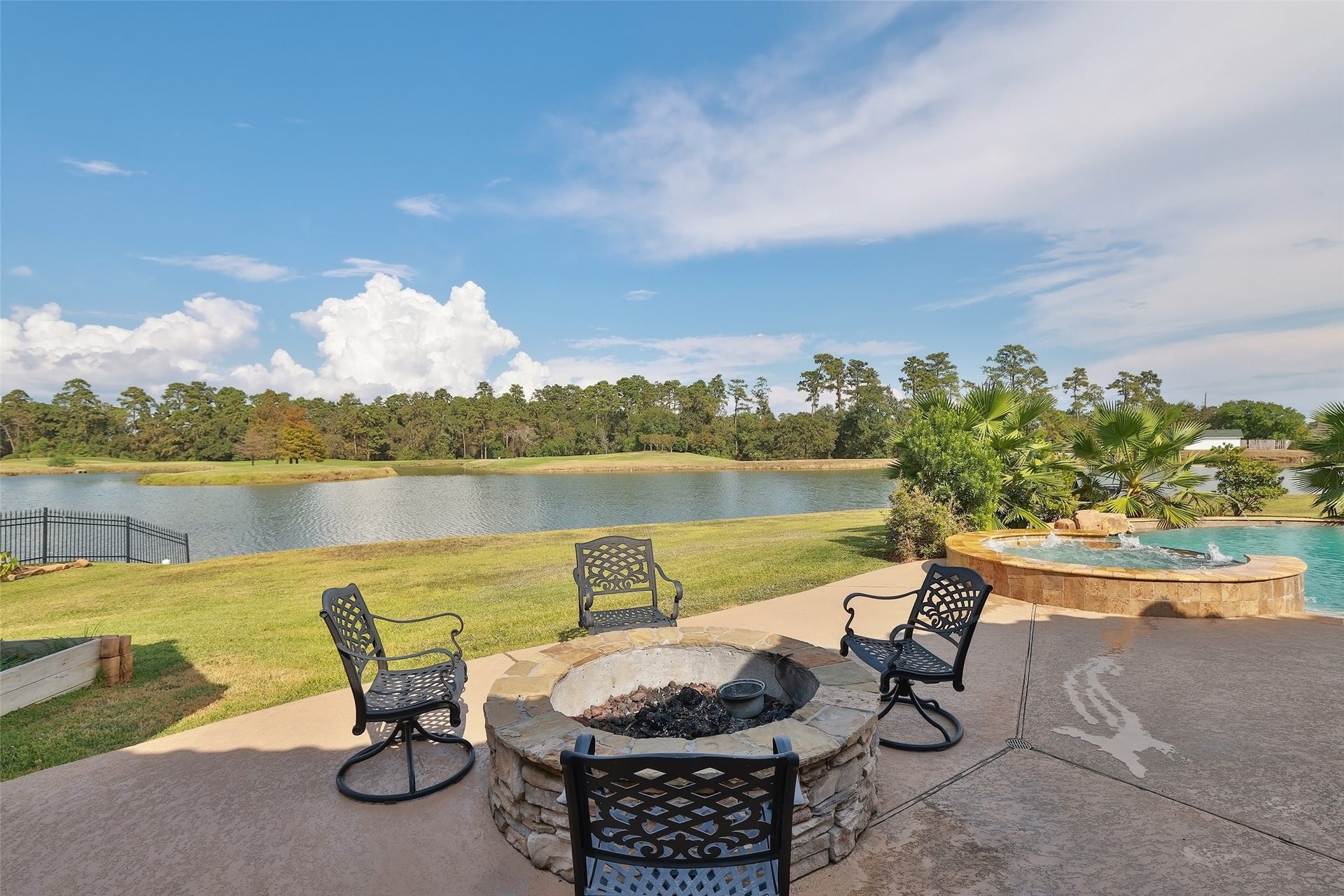 Large patio with firepit add to the charm of this backyard oasis.