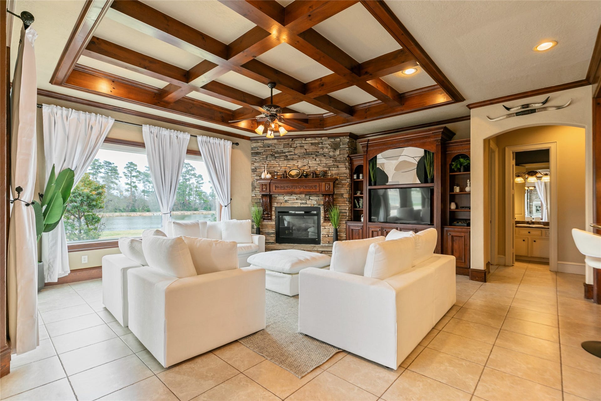 Light fills this gorgeous den with large windows overlooking the backyard oasis