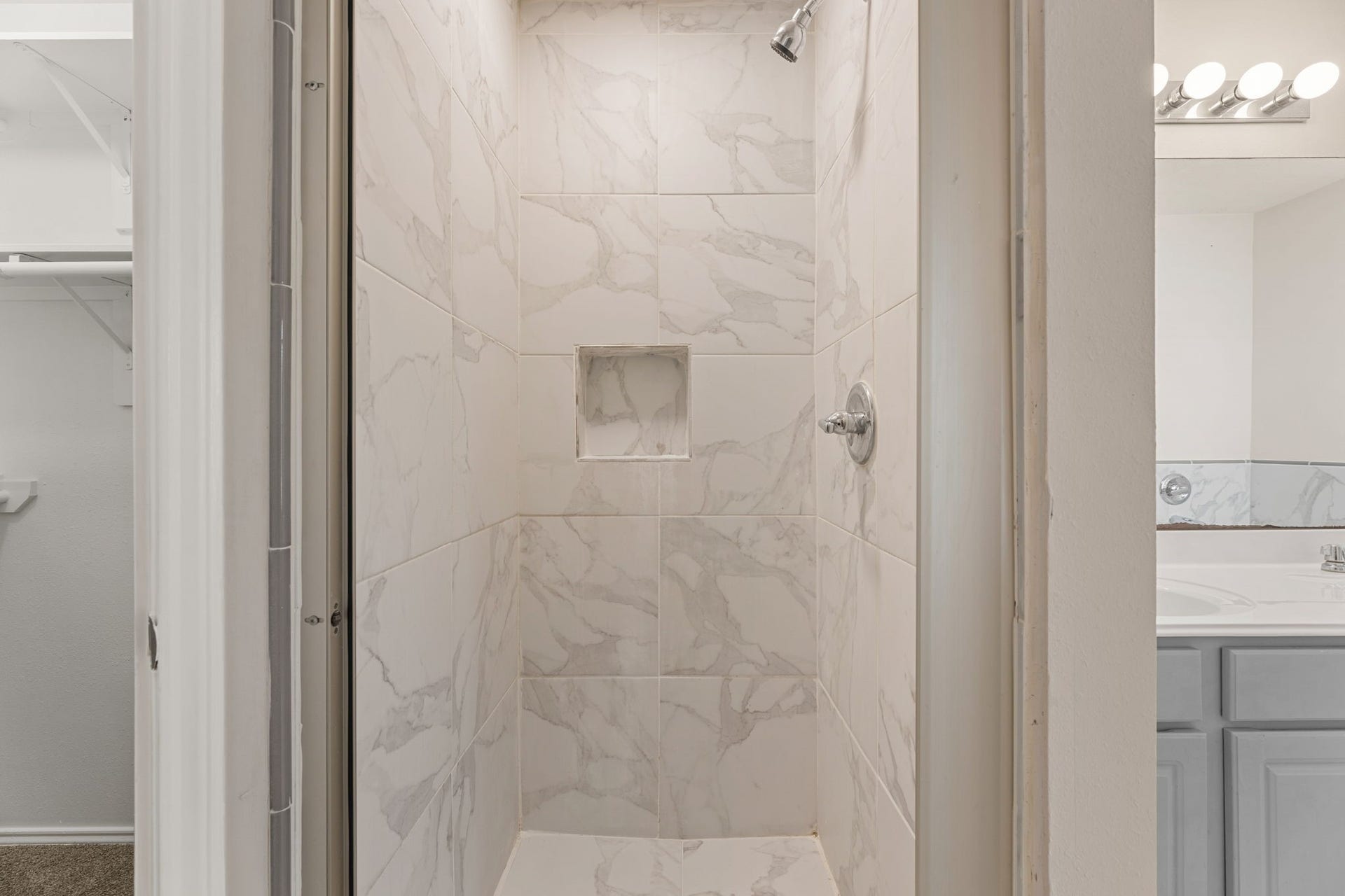 Floor-to-ceiling tile and a built-in niche give this shower a clean, spa-like feel.