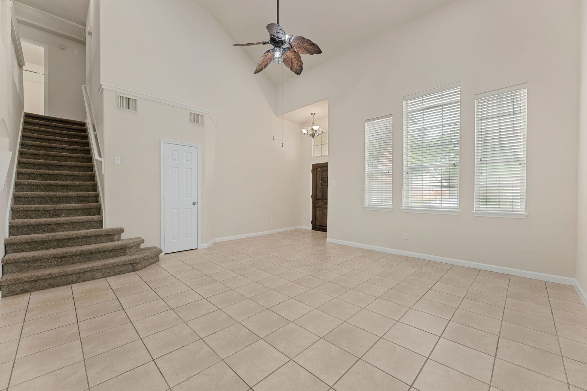 Tall windows fill the formal living area with natural light, and there's a convenient coat closet near the stairs.