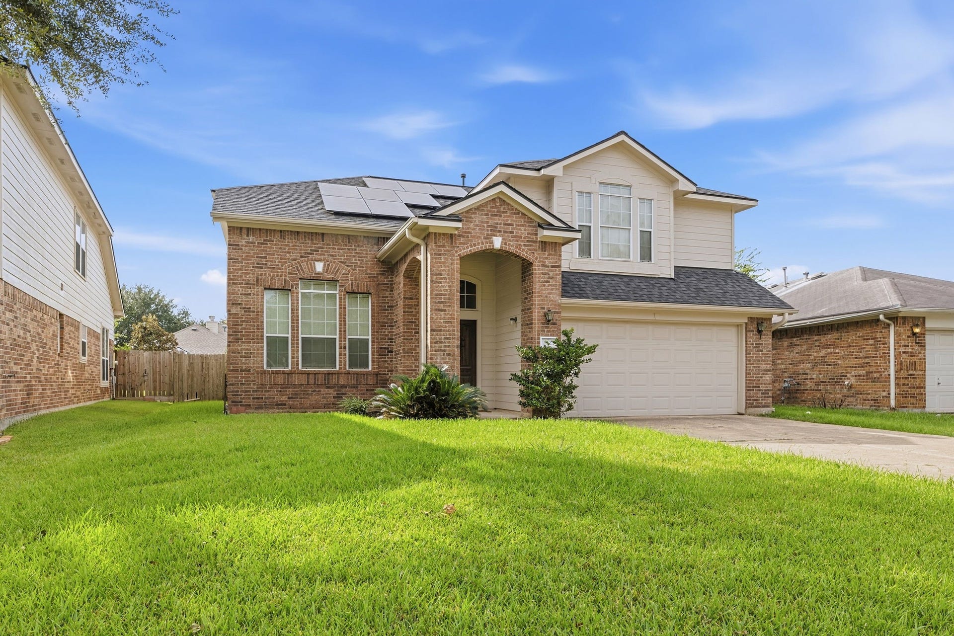 Solar panels on the roof help keep energy bills down, and there's a wide front lawn and a fenced backyard.