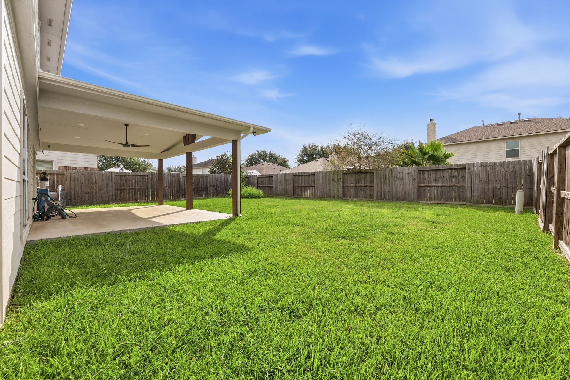 Shaded seating flows right into a spacious, fully fenced backyard.