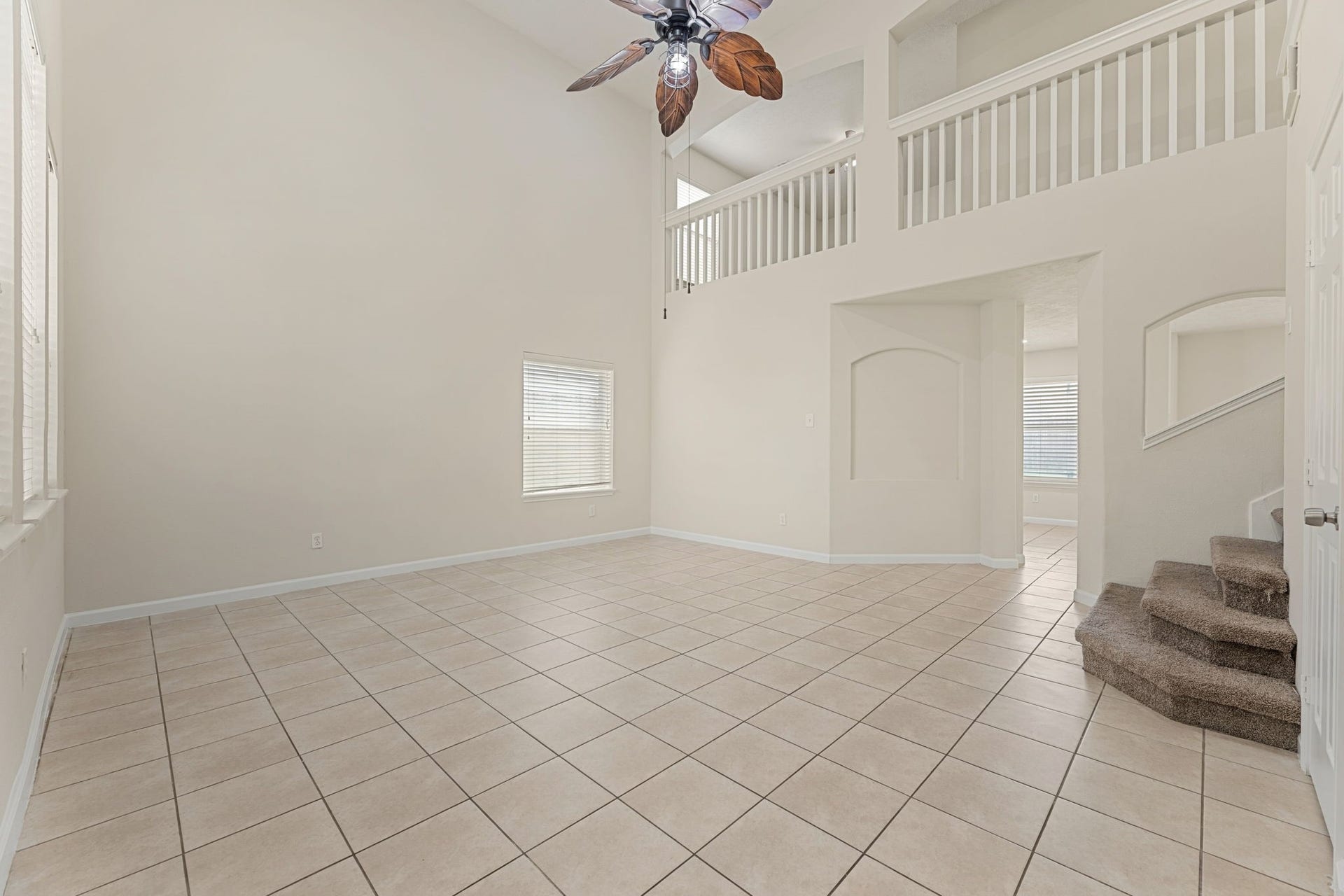 Double-height ceilings and a dramatic balcony overlook make this front living space feel bright and open.