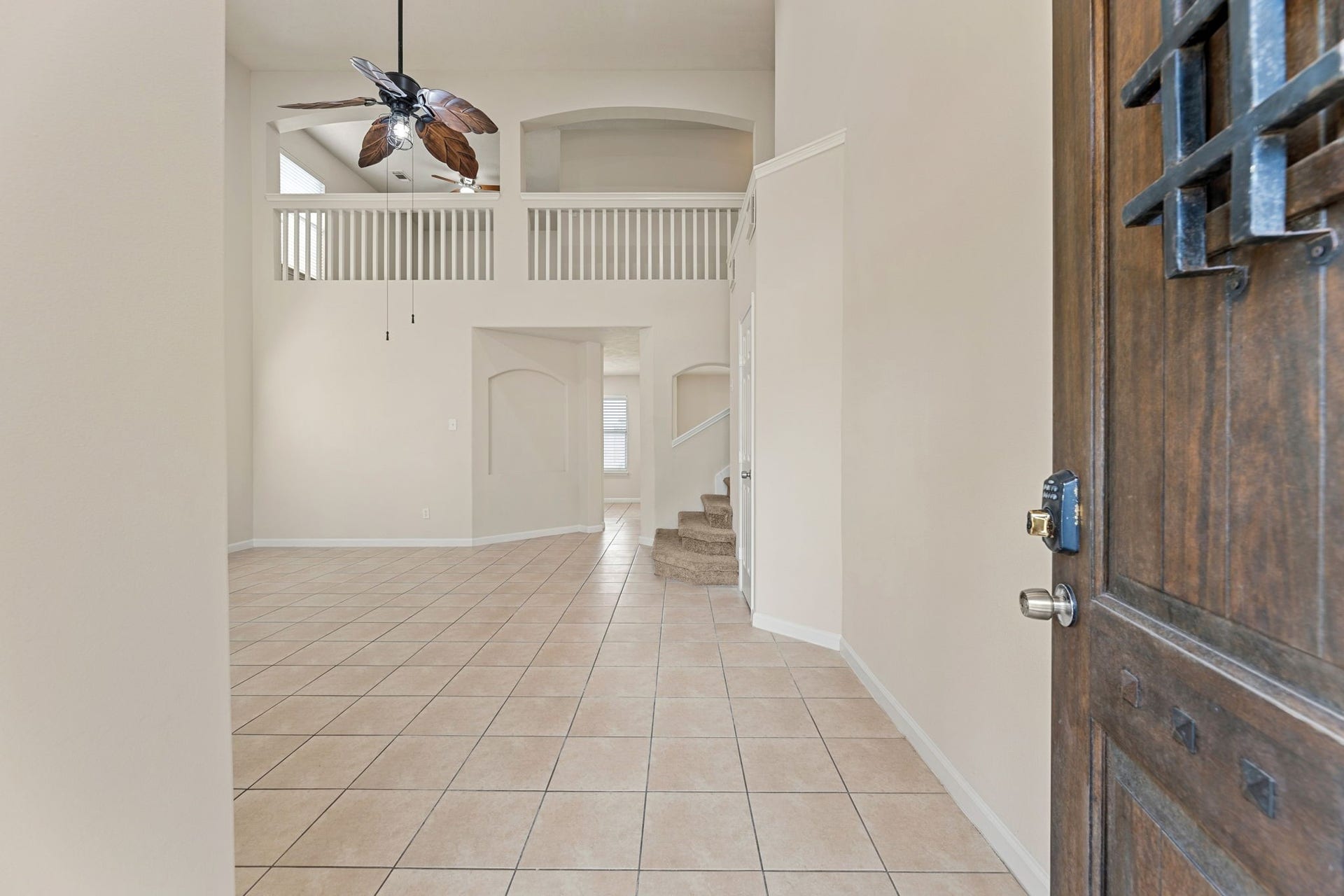 Step inside to high ceilings, a two-story overlook with open balconies, and tile flooring throughout the main level.