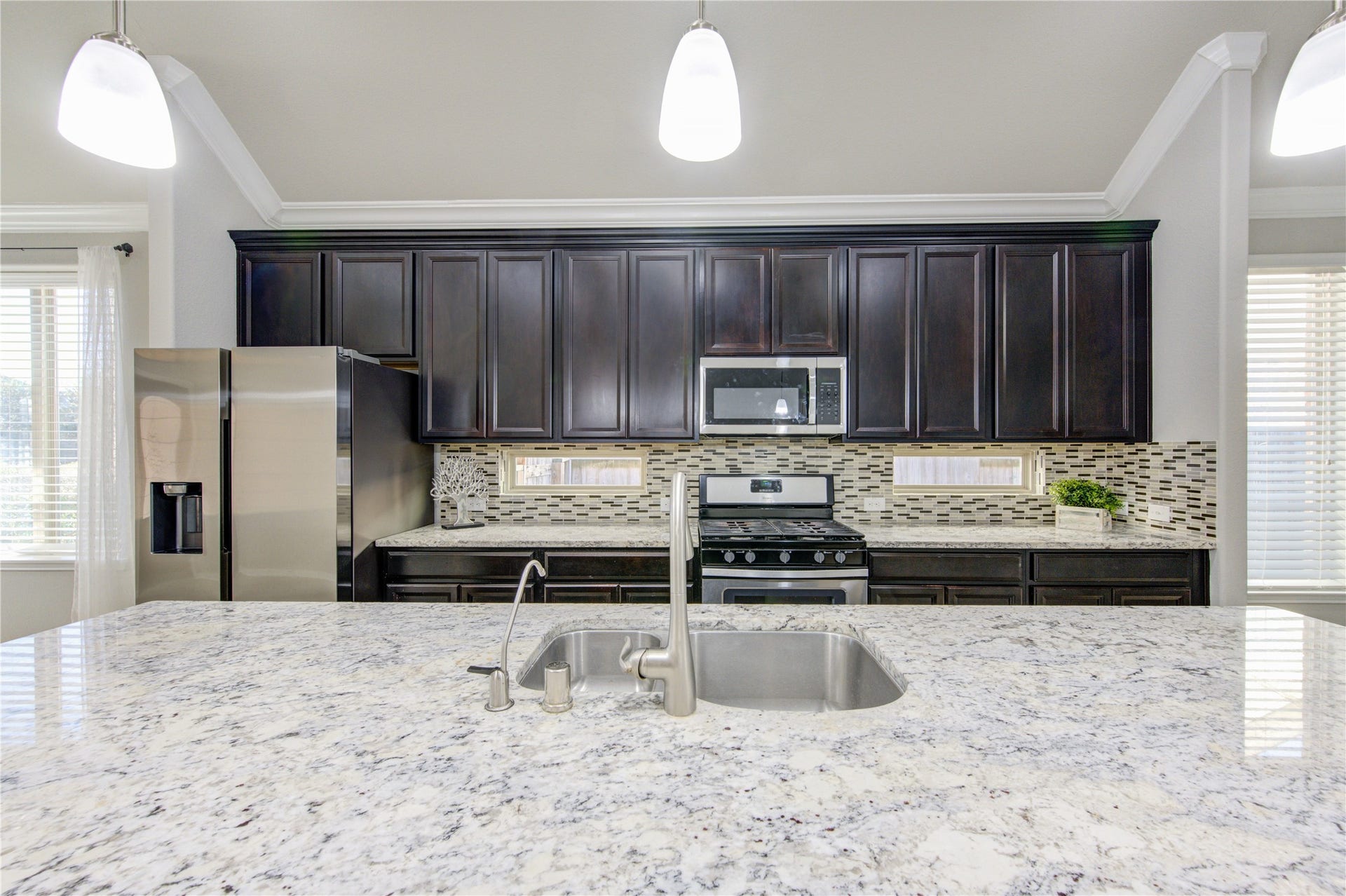 5314 Silver Ledge Drive, Katy, TX 77493 This is a bright, spacious living room with neutral-toned walls and tiled flooring. It features large windows with blinds, a ceiling fan, and a door leading outside. Perfect for a living area or open layout.