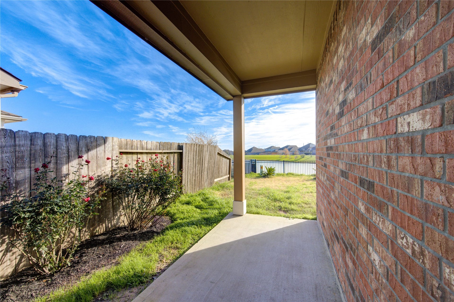 5314 Silver Ledge Drive, Katy, TX 77493 This photo showcases a serene neighborhood with a wide, calm lake and a fountain, surrounded by well-maintained lawns and houses. The sky is bright and clear, offering a peaceful and inviting atmosphere.