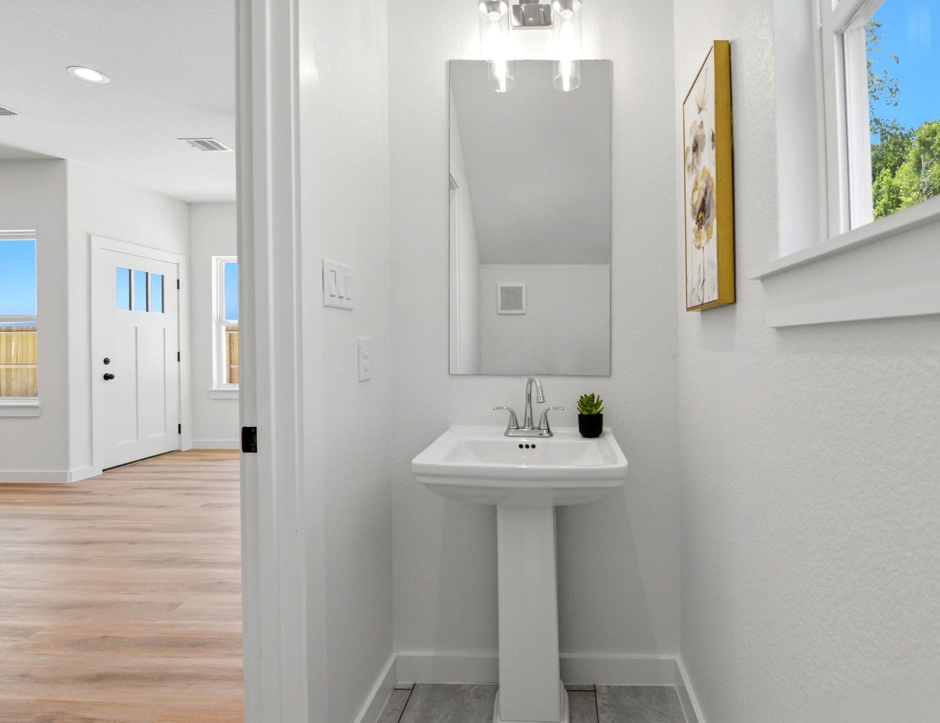 6117 Haight Street, Houston, TX 77028 Half bathroom downstairs. The space is bright with natural light from window.