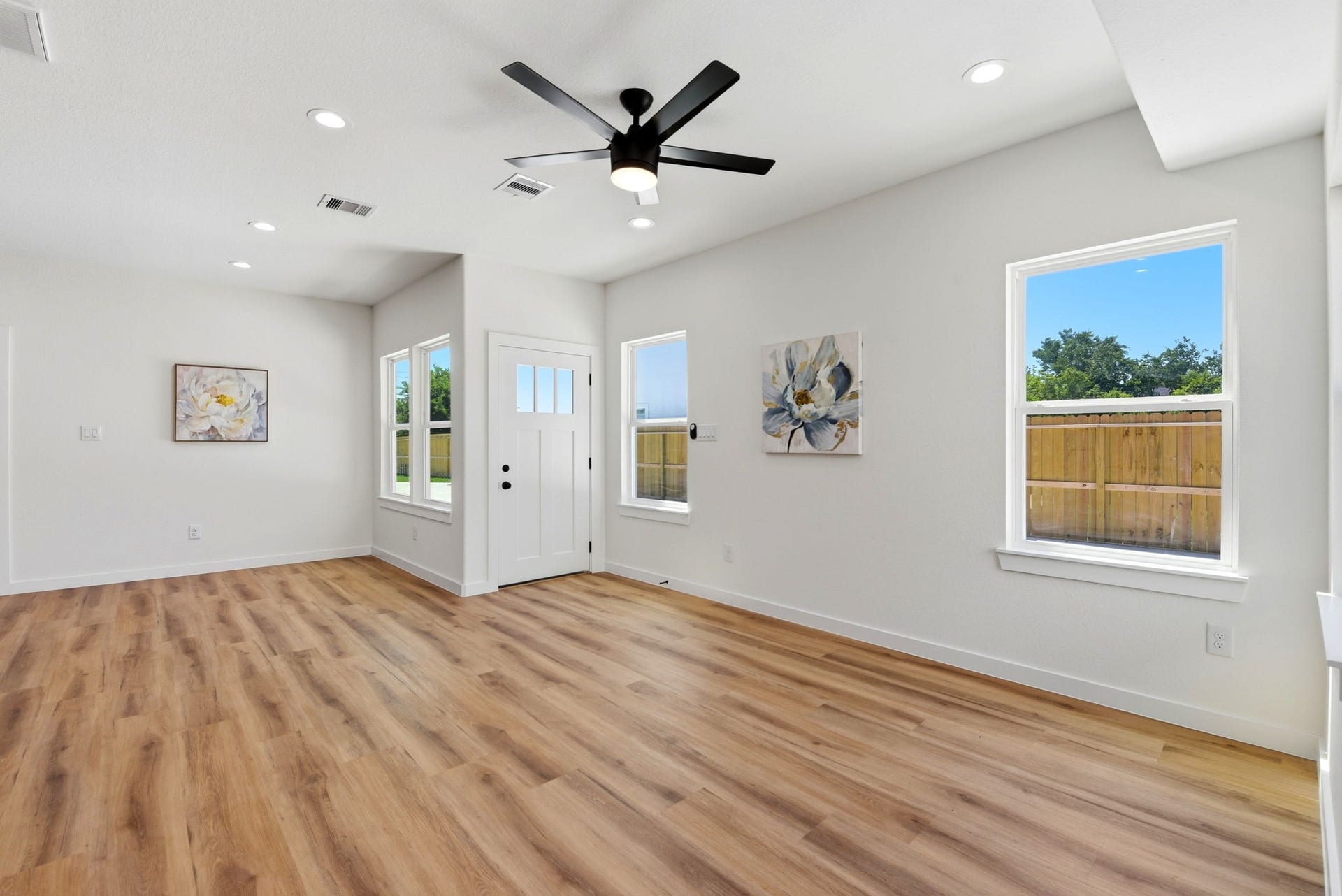 6117 Haight Street, Houston, TX 77028 A bright, open living space and dining area with large windows, water resistant vinyl plank flooring, and modern lighting.