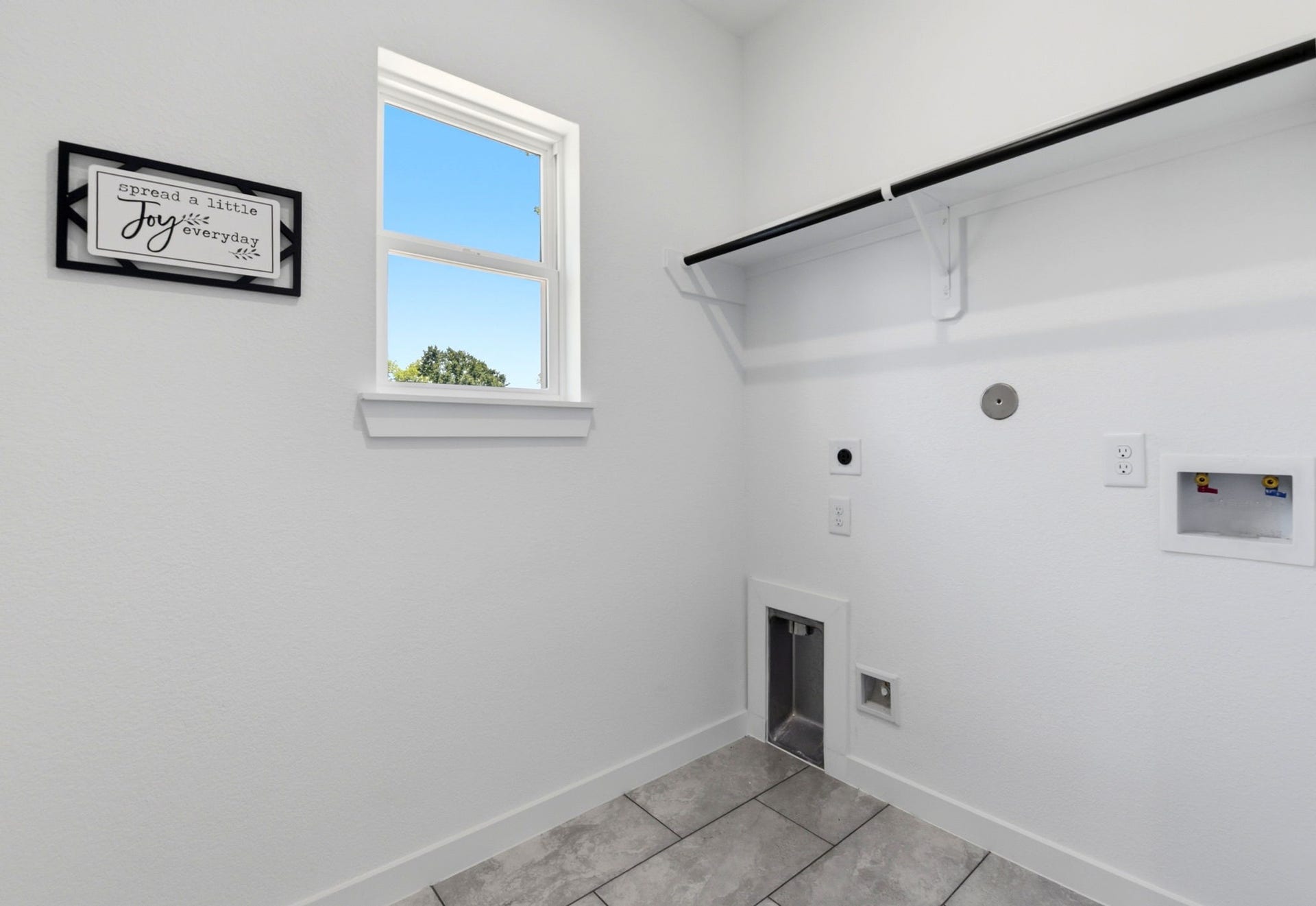6117 Haight Street, Houston, TX 77028 Bright, functional laundry room with a small window, tile flooring, and wall storage for organization. Gas and electrical connections available.