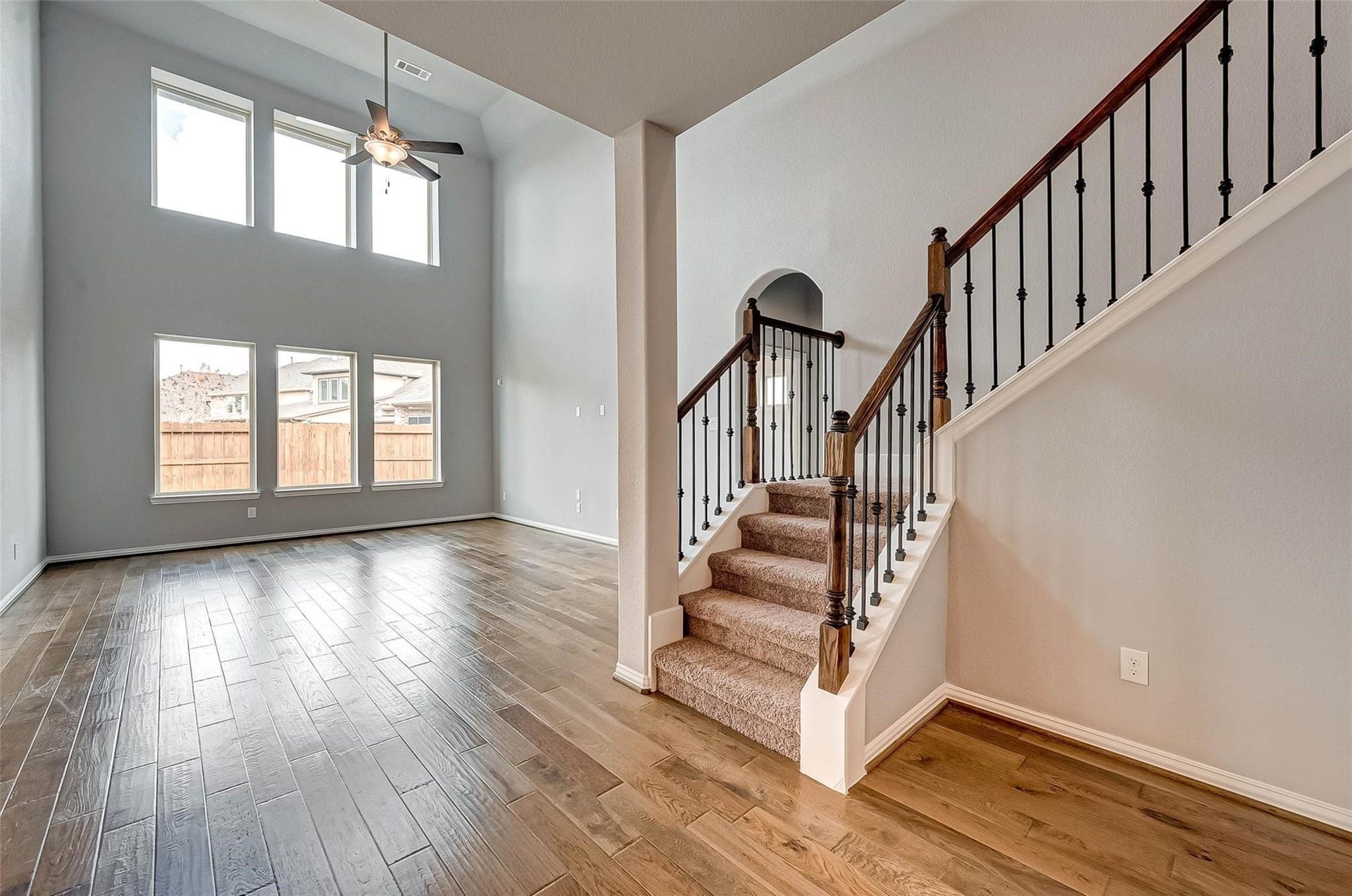 23514 San Ricci Court, Richmond, TX 77406 Spacious living area featuring soaring ceilings, wood flooring, and an abundance of natural light.